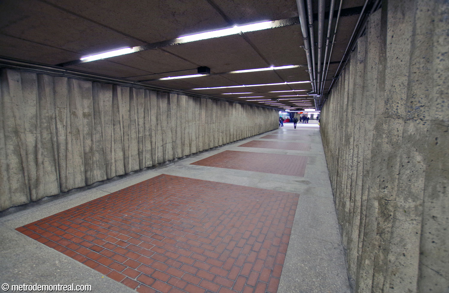 Le corridor entre la salle de contrôle et l'édicule Honoré-Beaugrand. On note la frise tailladée en béton sur les murs, motif partagé avec les murs des quais et des autres espaces intérieurs.