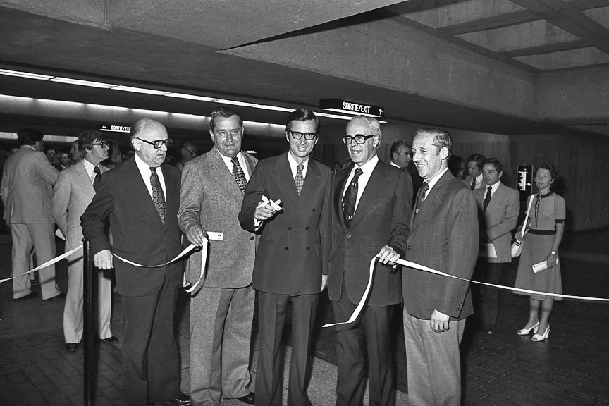 La cérémonie officielle d’inauguration de la station et du prolongement de la ligne verte vers l’est, le 4 juillet 1976. Dans l’ordre habituel : le maire de Montréal, Jean Drapeau; le directeur du BTM, Gérard Gascon; le premier ministre du Québec, Robert Bourassa; le président de la CTCUM, Lawrence Hanigan; et le ministre des Affaires municipales du Québec, Victor Goldbloom.