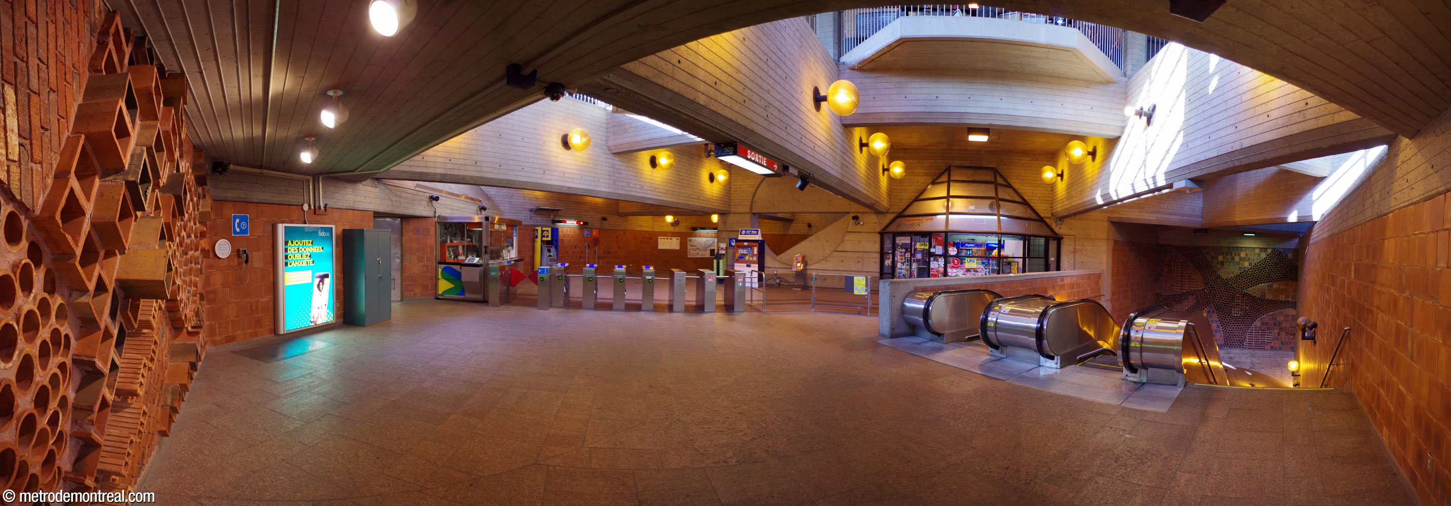 Vue panoramique de la salle de contrôle de l'accès Berri, éclairée naturellement grâce aux ouvertures vers le rez-de-chaussée. L'espace est agrémenté par deux murales créées par l'architecte, André Léonard, Le potager (gauche) et Les vents (droite, au-dessus des escaliers vers les quais).