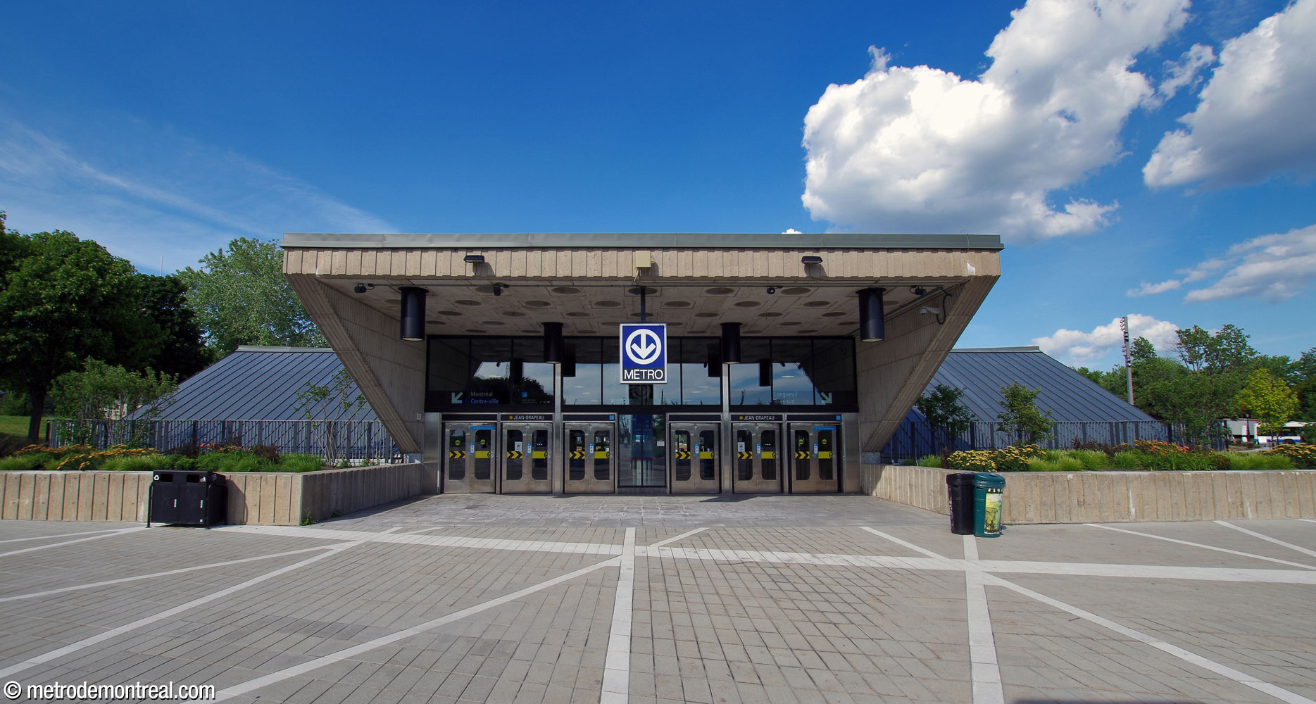 Le grand édicule unique de la station, vu du sud-ouest. Au centre, un large auvent projette au-dessus des entrées pour créer un grand portique.