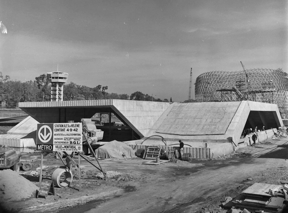 L'édicule en chantier en octobre 1966; le pavillon américain (la future Biosphère) est également en construction derrière lui.