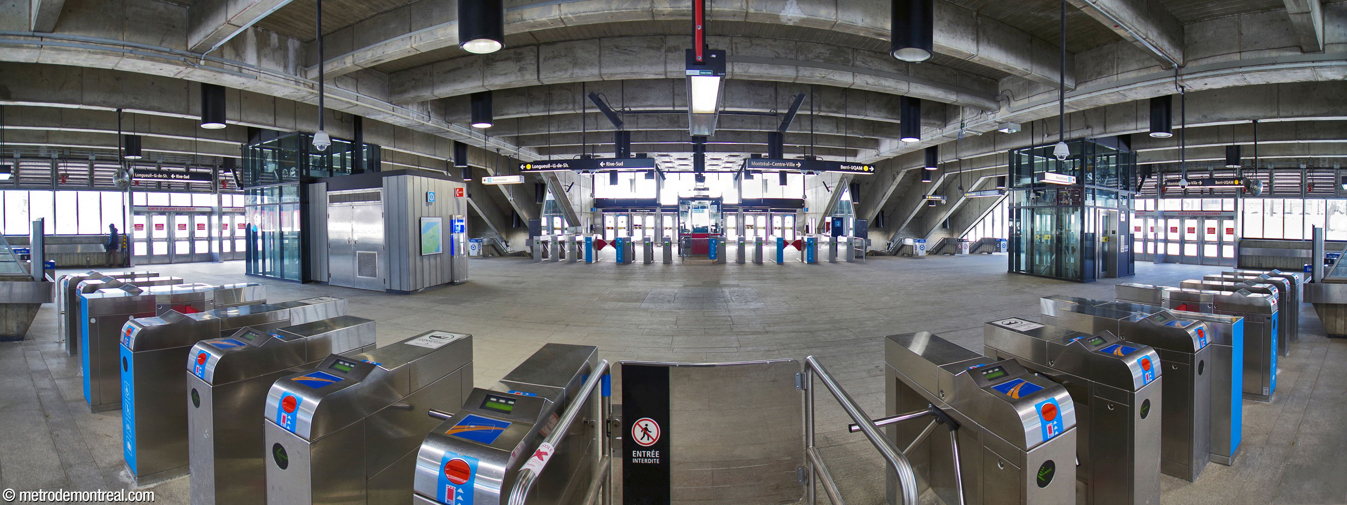 Panorama de la salle de contrôle vue de la ligne de perception nord-est. Les escaliers vers les quais se trouvent aux quatre coins de l'édicule, sous les parties penchées du toit.