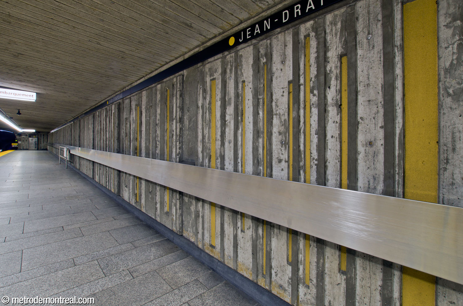 Le béton cannelé, les rayures jaunes et la main courante en acier inoxydable des murs des quais.