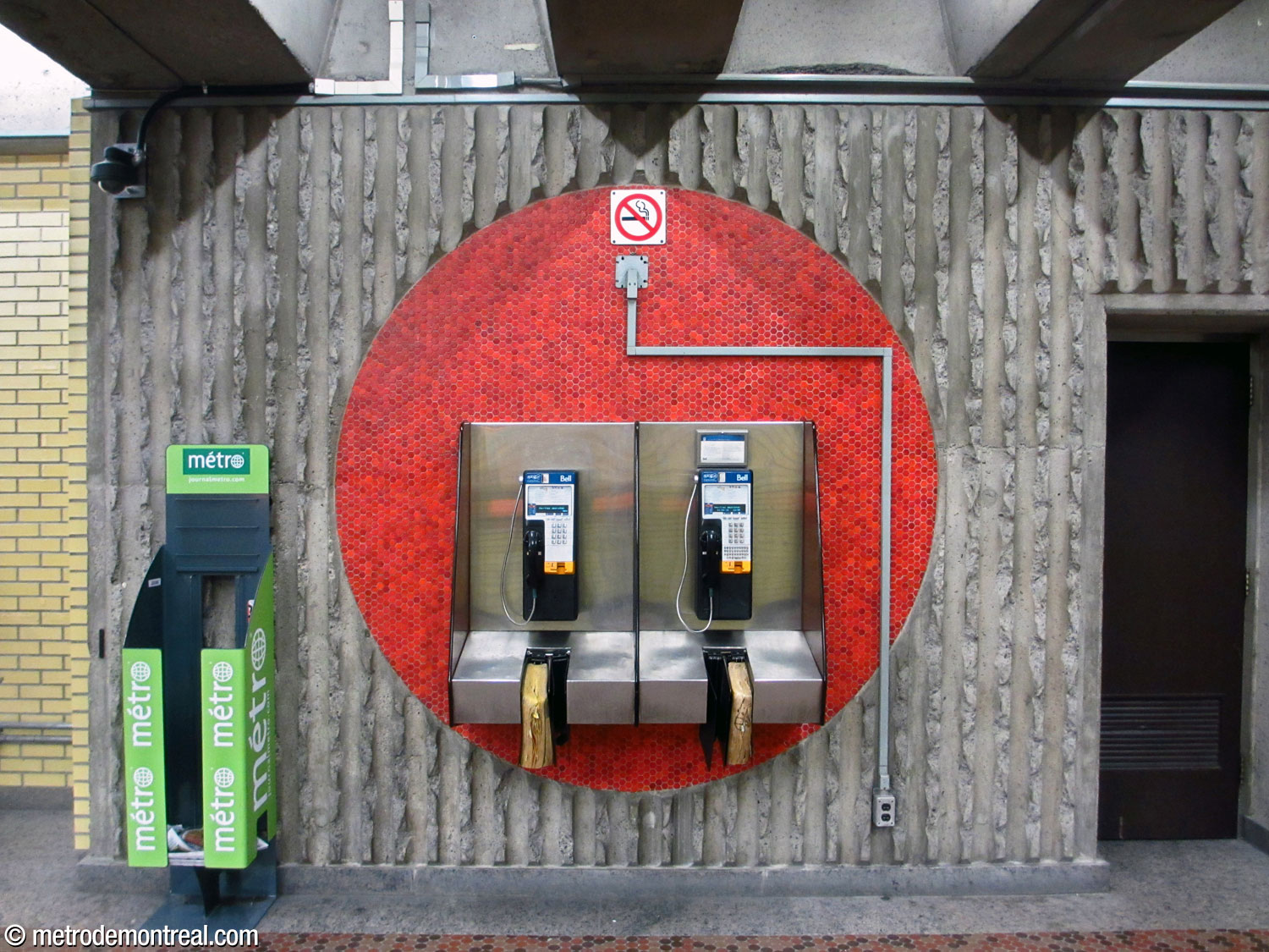 Un grand cercle en mosaïque derrière deux téléphones dans la salle de contrôle.
