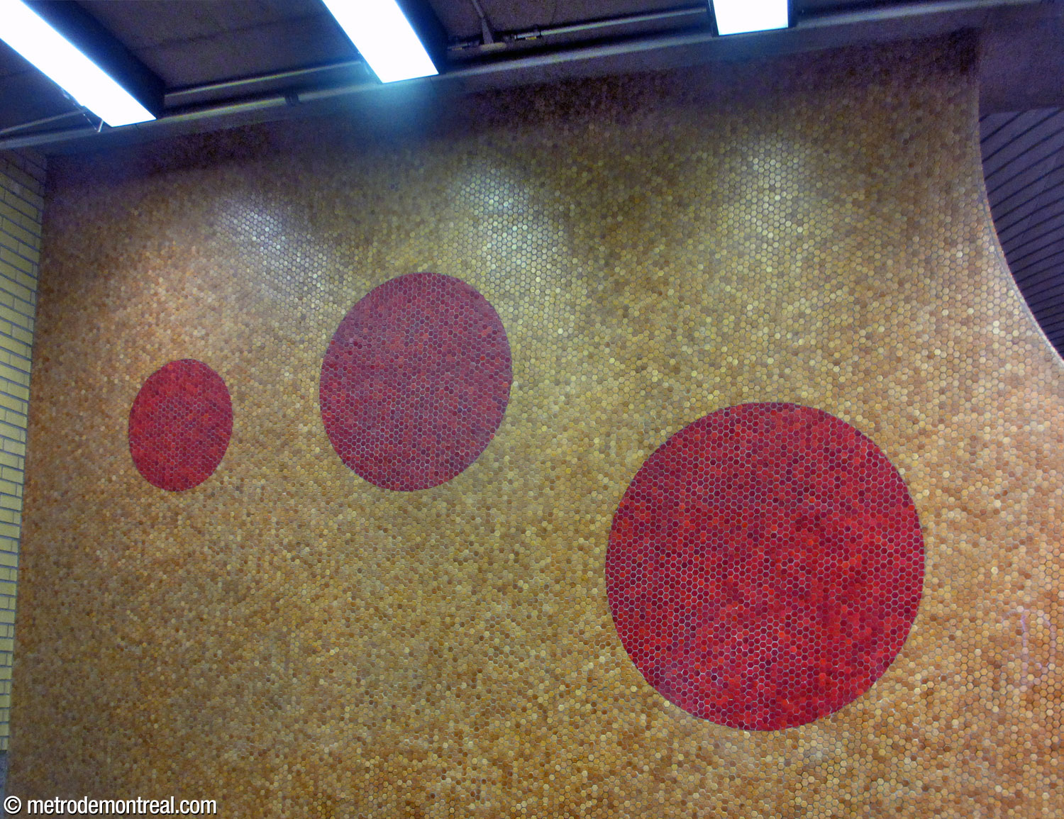 Séquence de trois cercles en mosaïque au mur de la cage de l'un des escaliers vers les quais.