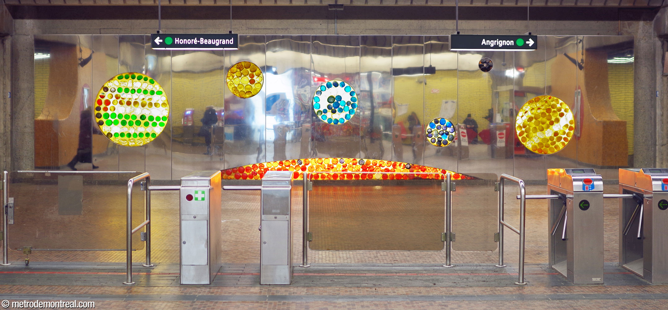 L'installation murale, œuvre de l'architecte de la station Marcel Raby, longe le mur ouest de la salle de contrôle. Sa surface en acier inoxydable poli ajoute à l'ouverture de l'espace et ses ouvertures contiennent de grandes billes amorphes de verre coloré illuminées de l’intérieur du boîtier.