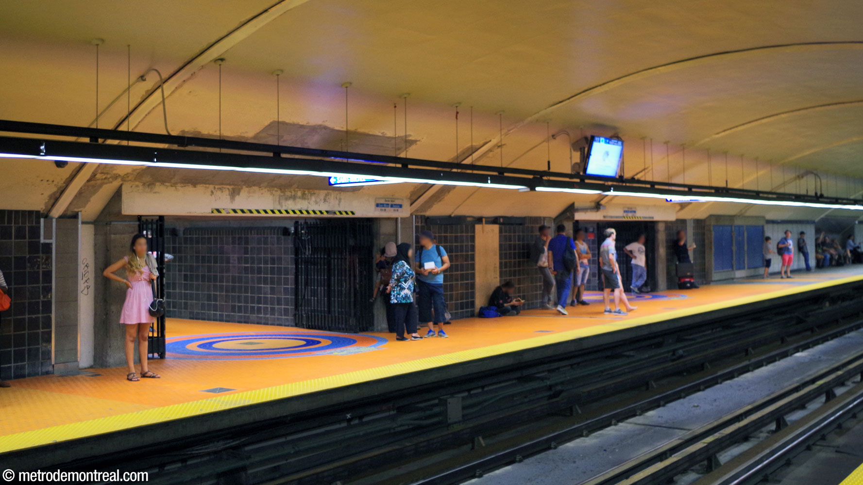 Sur le quai Côte-Vertu, les ouvertures des couloirs communiquant avec la galerie ouest sont marquées par des rosaces bleues dans l’étendue de carrelage orange insérée dans le pavage d'origine.