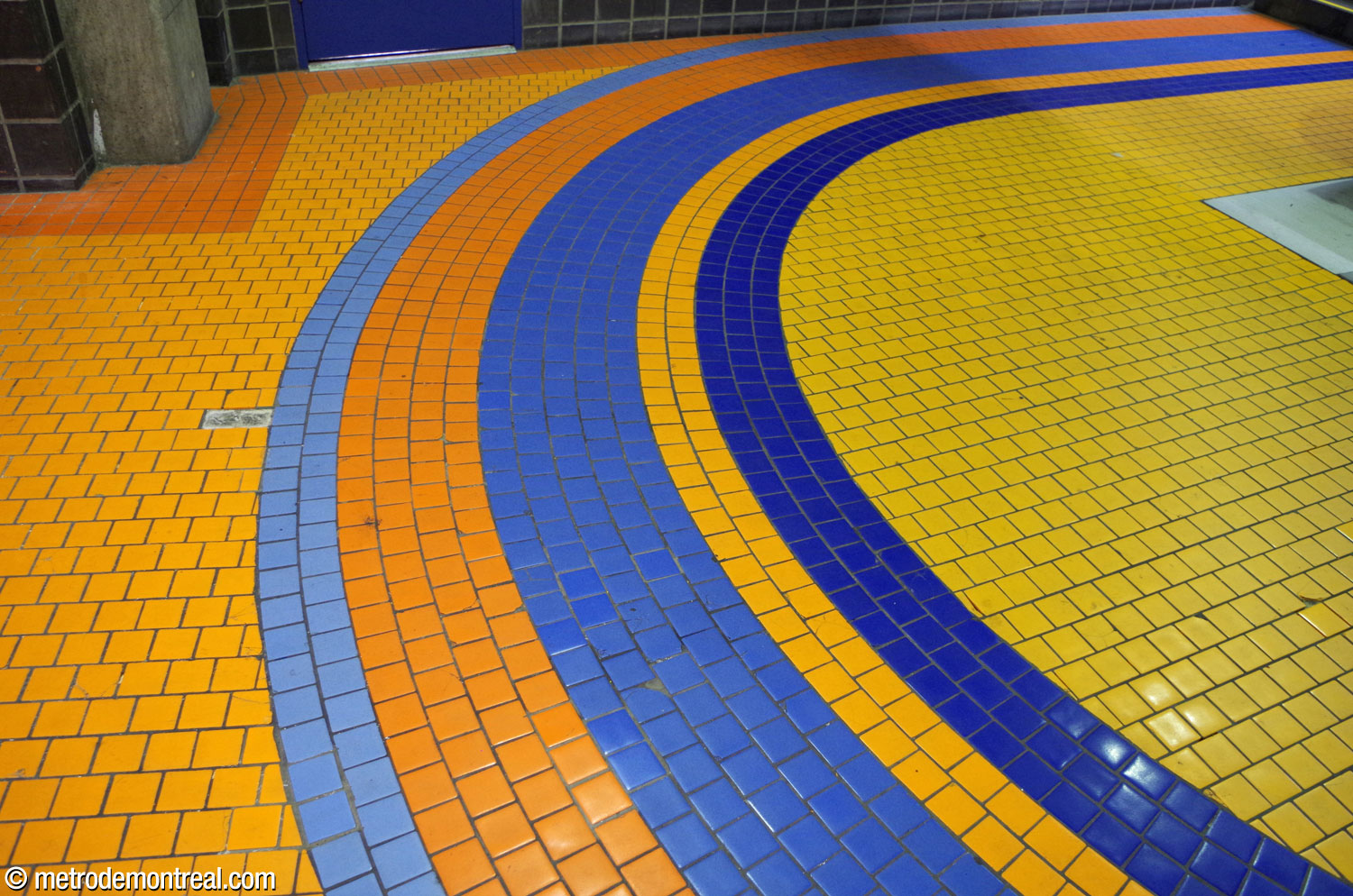 Un grand demi-cercle (appelé « rosace » par l'architecte) dans le carrelage en grès cérame Sialex. Celui-ci se trouve au niveau supérieur de la galerie est (d'où le fond orange) et sa couleur bleue démarque la tête des escaliers vers la ligne bleue.