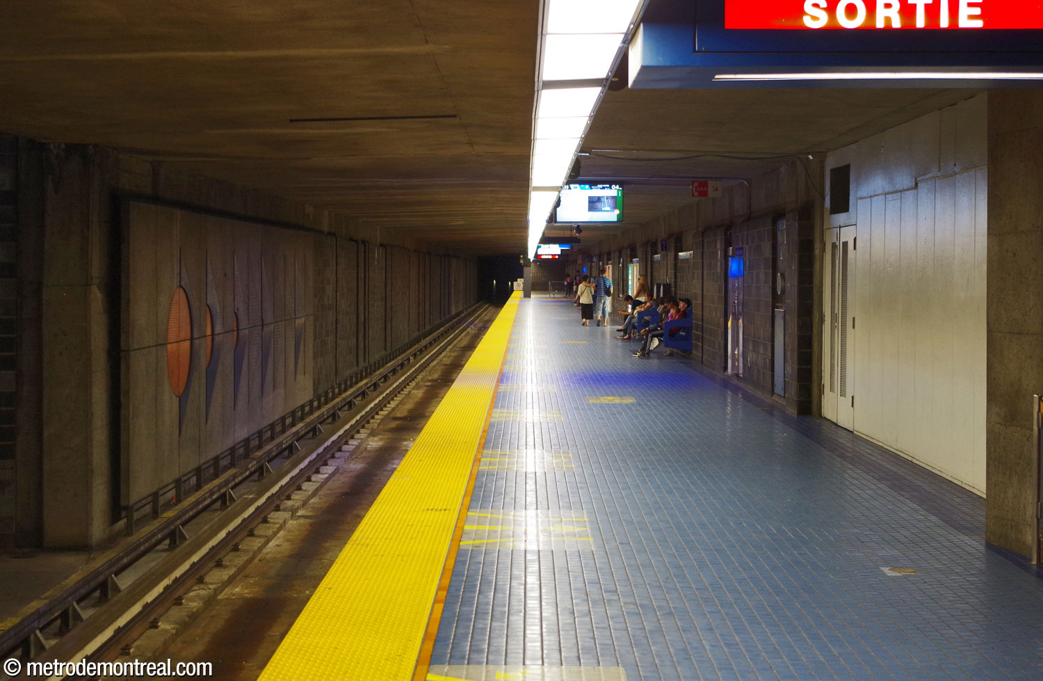 Le plafond plat du quai Saint-Michel indique qu'il se trouve sous le quai Snowdon. L'une des murales de Gilbert Sauvé se trouve à gauche au-dessus des voies.