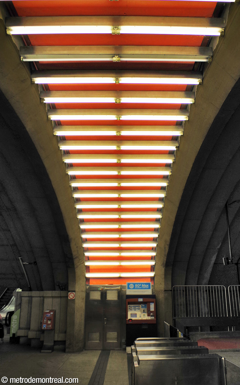 Une arche illuminée par des tubes fluorescents surplombe la ligne de perception dans la billetterie de la station.