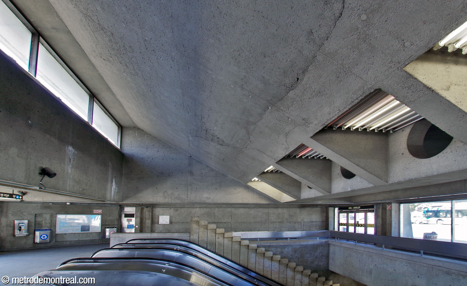 Vue à travers la trémie d’escalier dans l’édicule Sherbrooke Nord. Au-dessus de l’escalier, le toit reprend son angle en montant vers une claire-voie.