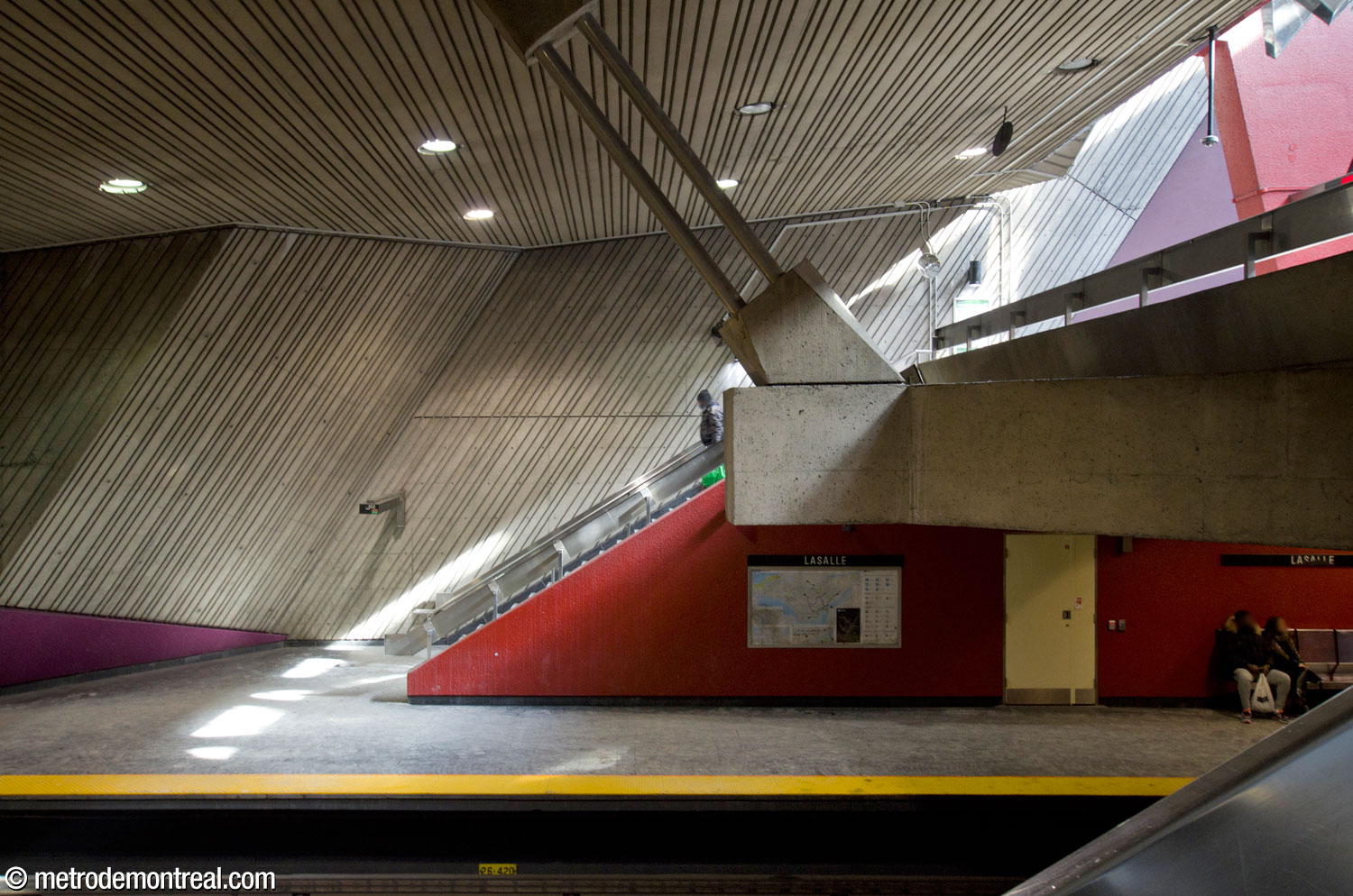 Large diagonal concrete beams suspended from the ceiling by metal rods help to support the mezzanine. In the background, a sunbeam from the light shaft shines along the staircase down to the Honoré-Beaugrand platform.