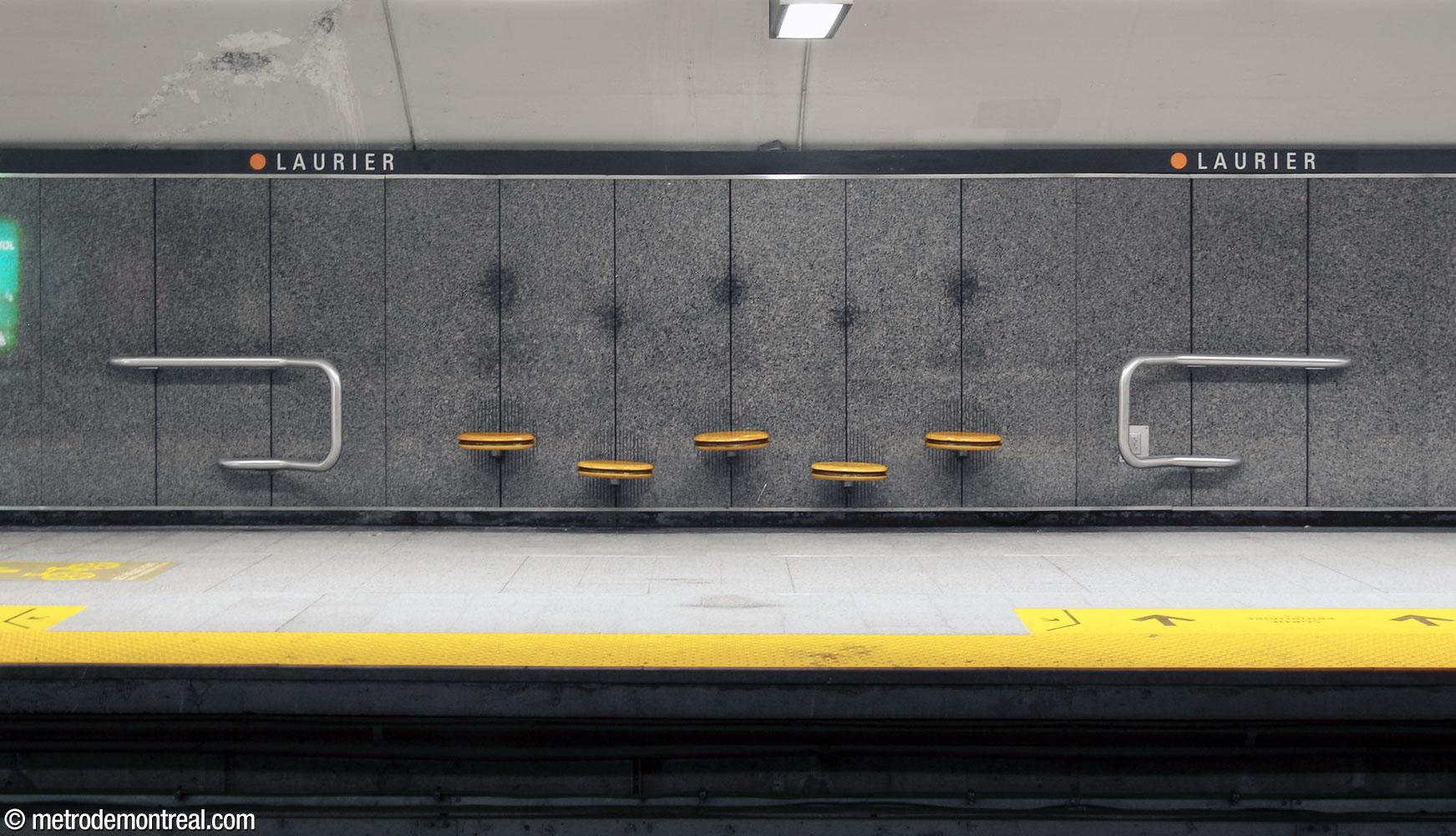 L'un des ensembles de sièges en bois, de forme ovale et disposés à hauteurs alternantes, au niveau des quais. Au-dessus, les célèbres « fantômes » de la station : les traces laissées par les têtes des passagers au fil des décennies.