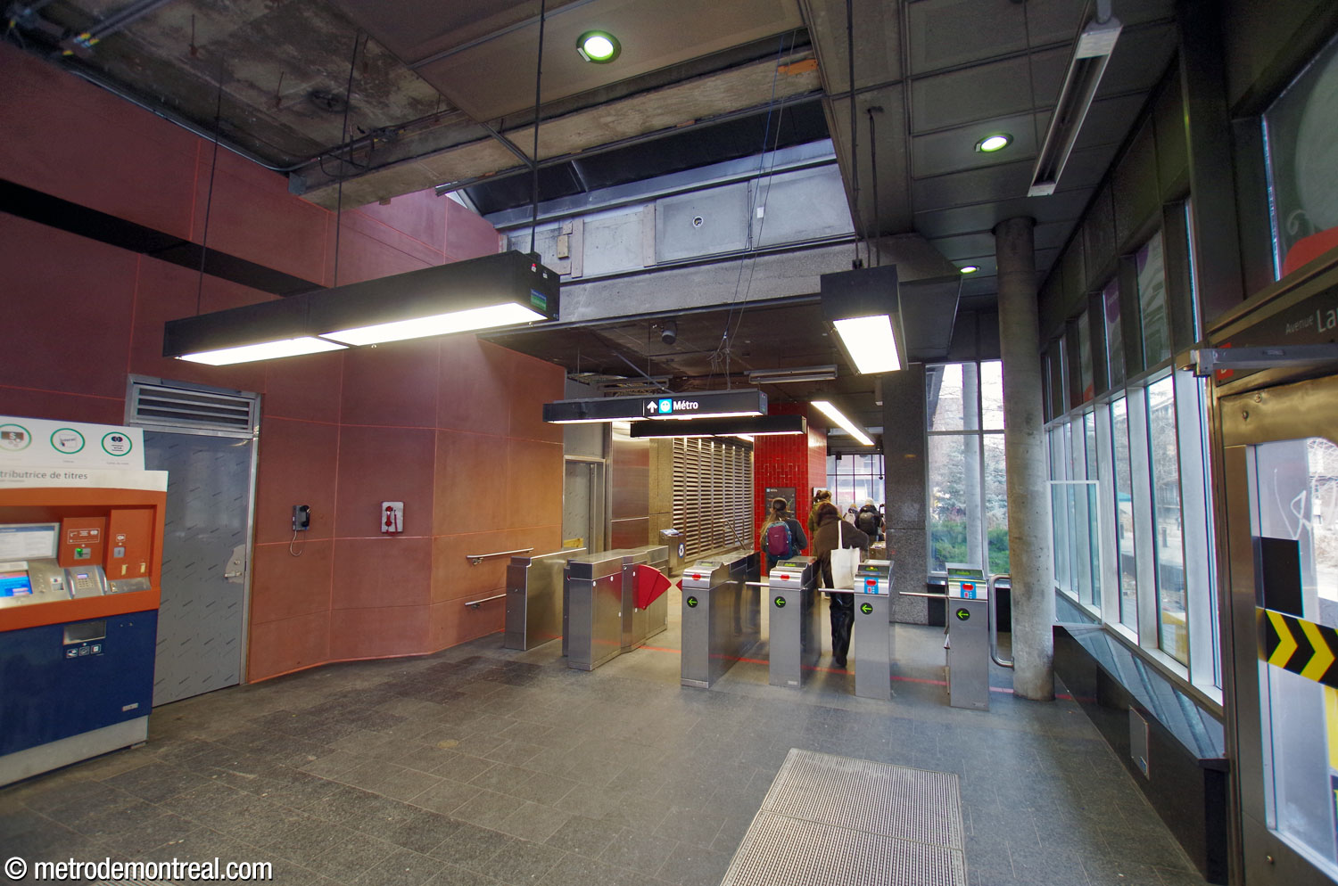 Intérieur de l'édicule nord, perspective vers l'est sur la ligne de perception sans personnel et les escaliers vers les quais. Les murs-rideaux vitrés sont supplémentés par un lanterneau.
