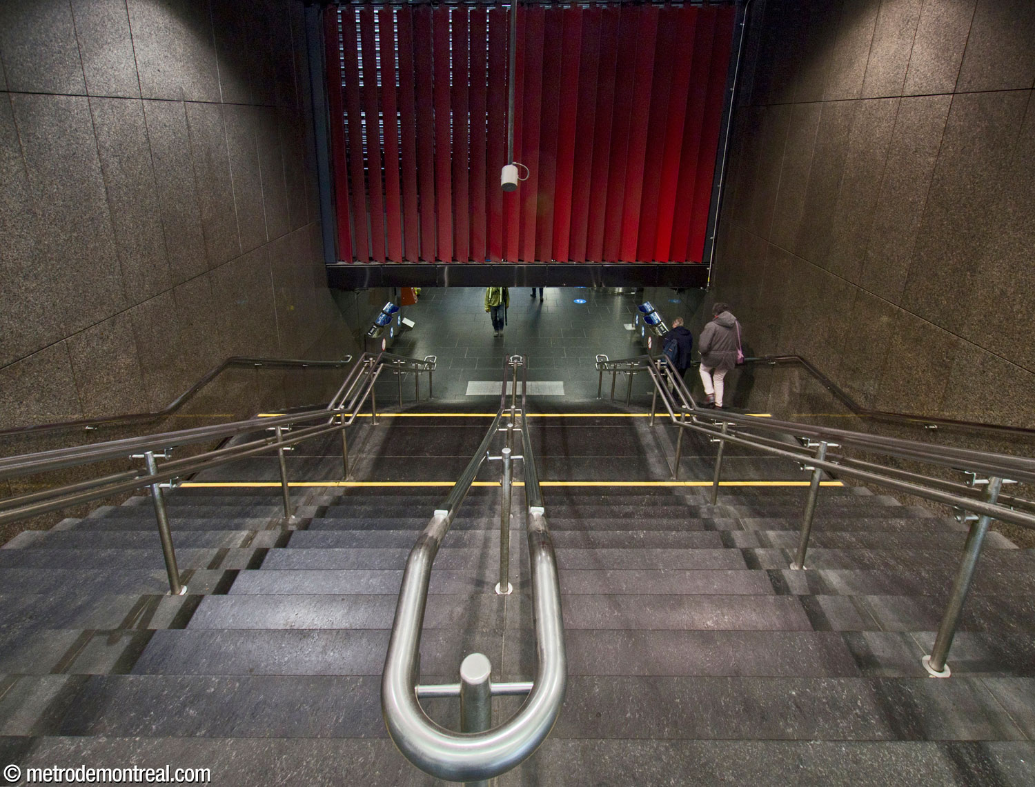 Le large escalier reliant l'édicule Saint-Joseph au niveau de la billetterie. La grille rouge, dissimulant une grille d'aération, a été ajoutée vers 2016 et ressemble à d'autres situées dans l'édicule de la station Rosemont avoisinante.