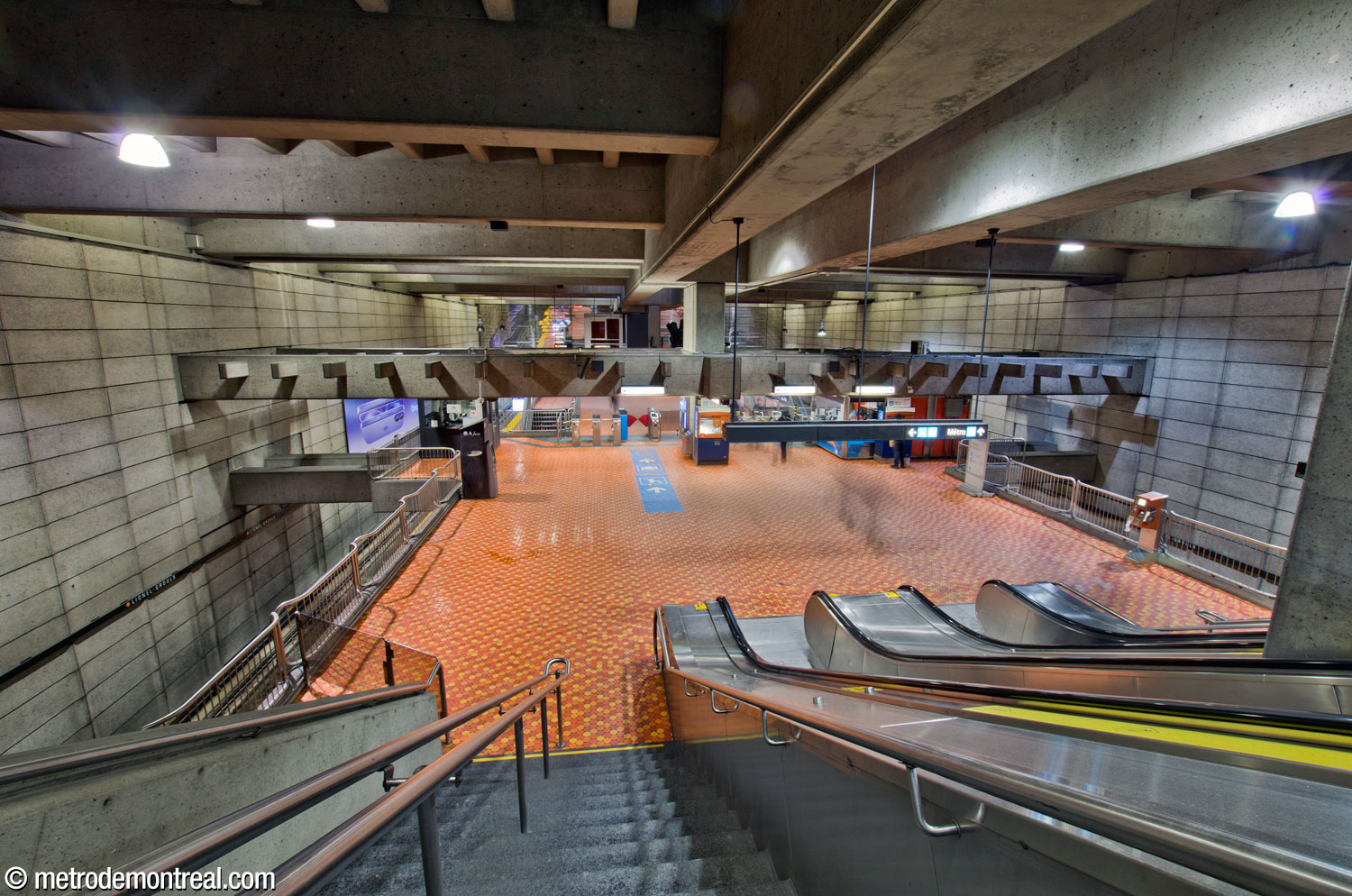 Vue donnant sur la mezzanine et la billetterie à partir de l'escalier vers la sortie.