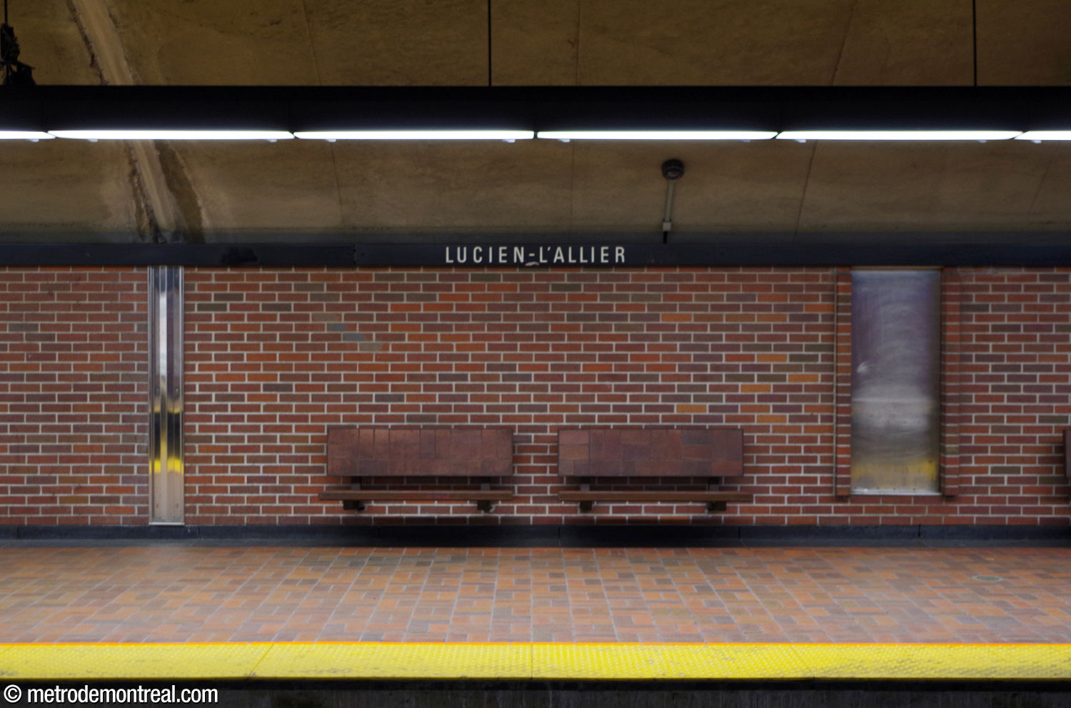 The platform benches are surfaced in terracotta tiles; the walls share the same warm brown brick as the upper parts of the station.