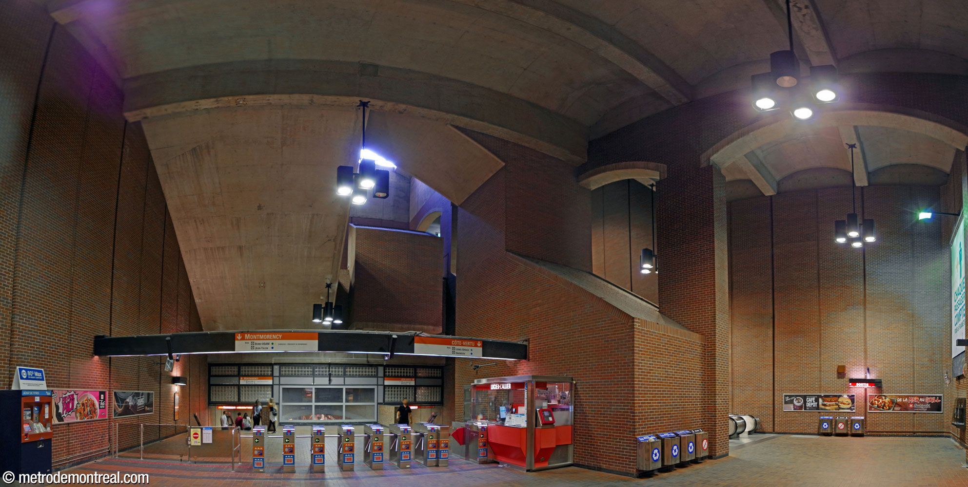 The ticket hall with the central light and air shaft above. Beside the ticket booth, an angular central core containing technical facilities rises up to connect the different levels of the station. The rear of the stairwell between the first and second landings hangs over the access to the platforms.