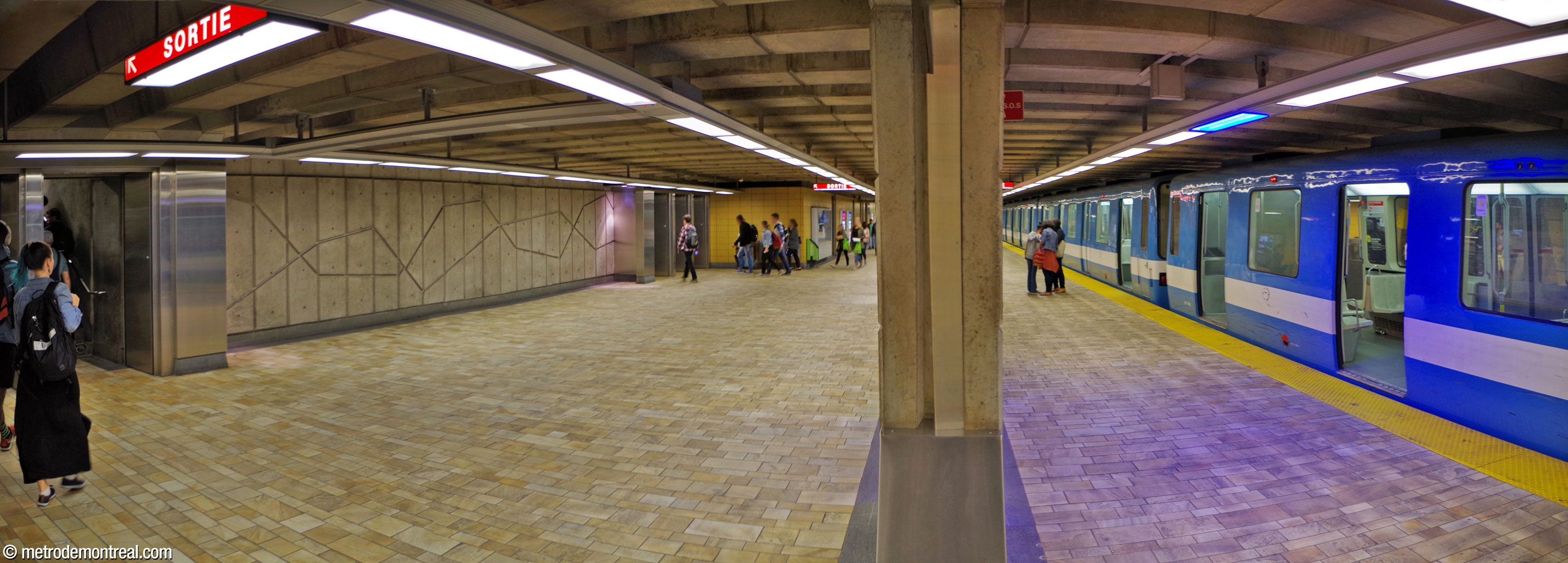 Passengers head from the arrival platform toward the staircases. Uniquely, this station has no turnstiles or other barriers through which exiting passengers must pass. A relief by station architect Jean Dumontier is located between the two exits.