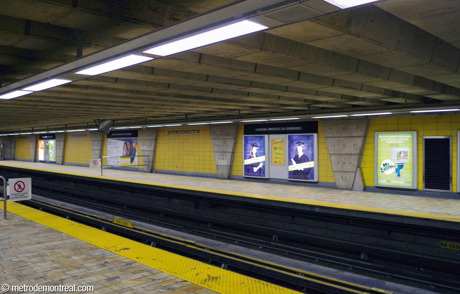The row of columns continues toward the head end of the arrival platform, embedded in the wall. Like the rest of the wall surfaces, the interstices are clad in plain rectangular yellow ceramic.