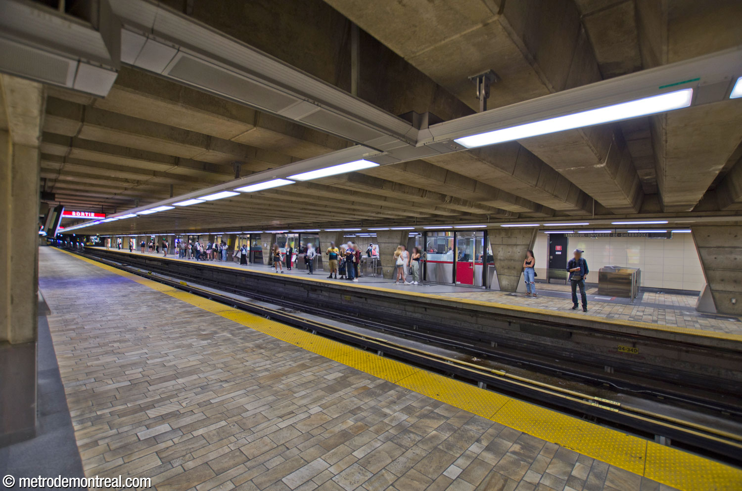 The departure platform, with crowds congesting the areas in front of the platform-level turnstiles.