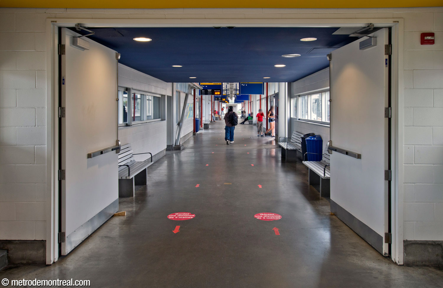 One of the fully enclosed platform wings of the Terminus Longueuil bus terminal, with glazed walls overlooking the driveways and access doors for embarkation.