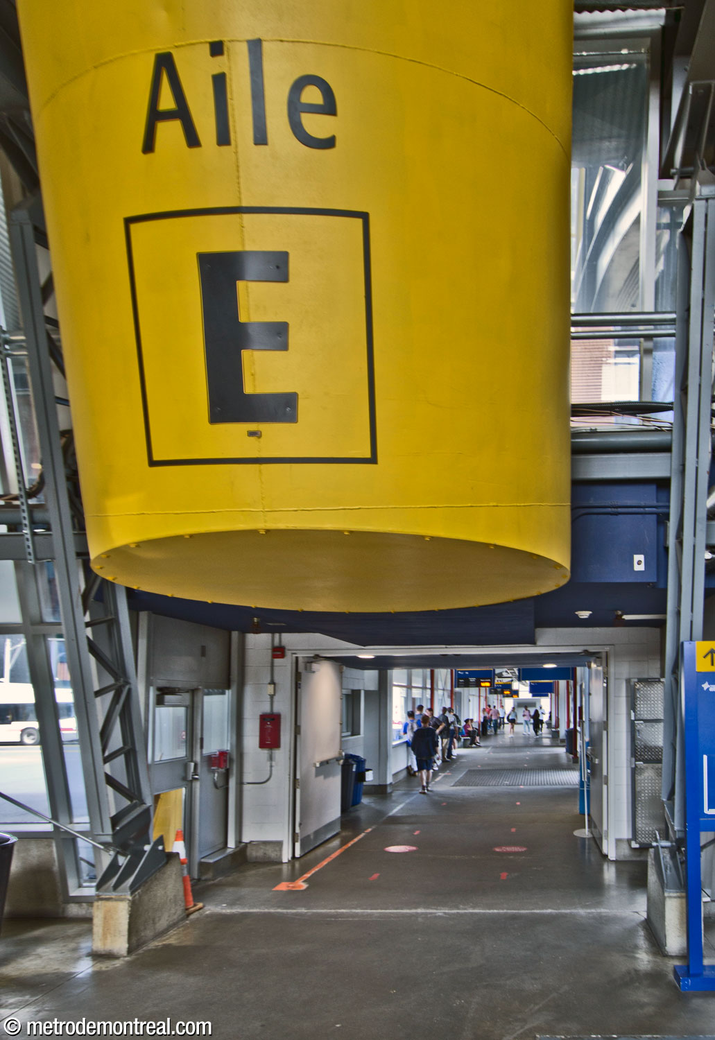 Entrance to one of the platform wings of the Terminus Longueuil bus terminal, signed with a huge yellow overhead cylinder.