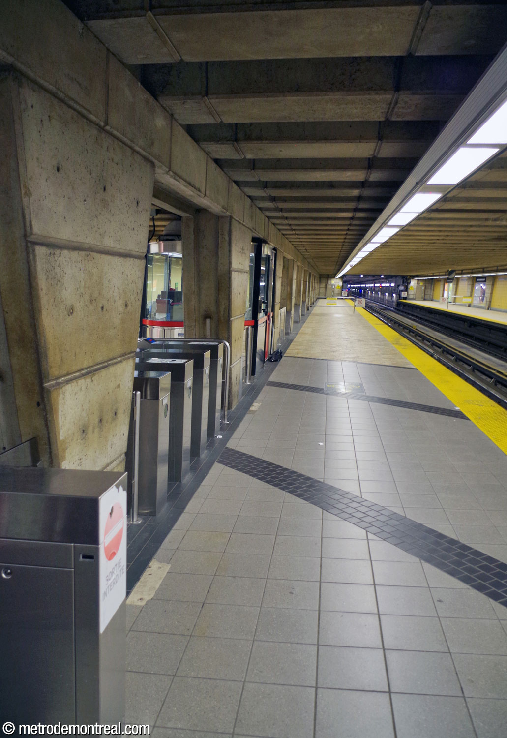 The departure platform, with the ticket hall turnstiles visible between the pillars.