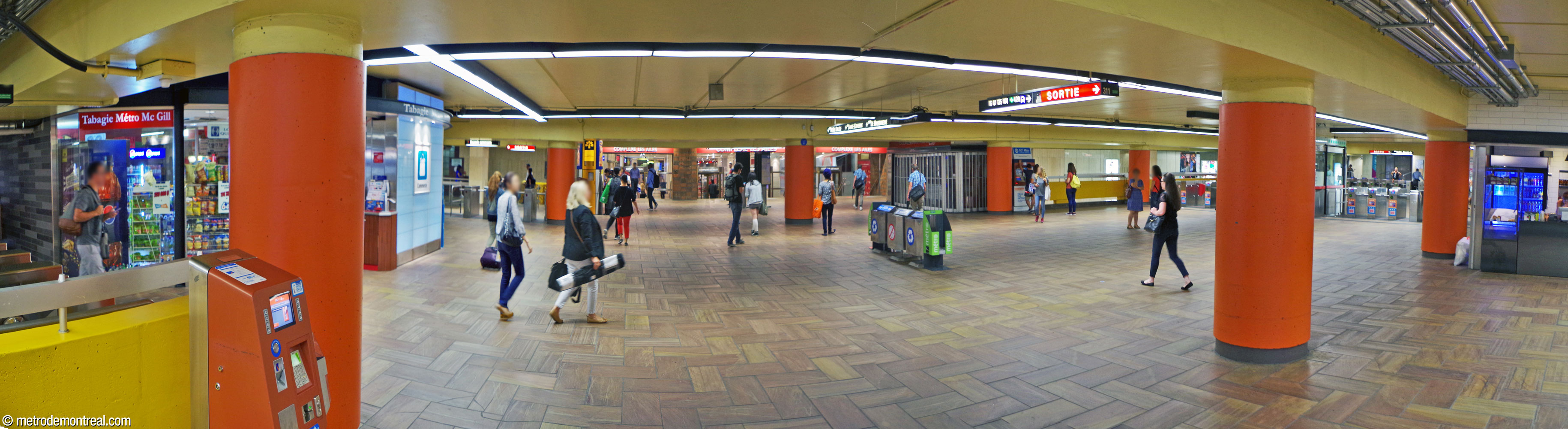 The central concourse, leading to the western ticket hall. In the background is the eastern entrance to Centre Eaton, with Maurice Savoie's terra cotta reliefs, as well as the south passage. To the left are the turnstile rows at the heads of the two exit-only staircases. Behind the viewer is the north passage and the access to Le 2020.