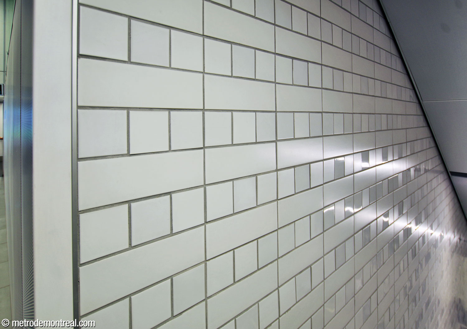 The distinctive pattern of white ceramic tiles in the stairwells down to the platforms. The pattern formed by matte and gloss tiles is specific to this station and is inspired by the windows of downtown buildings.