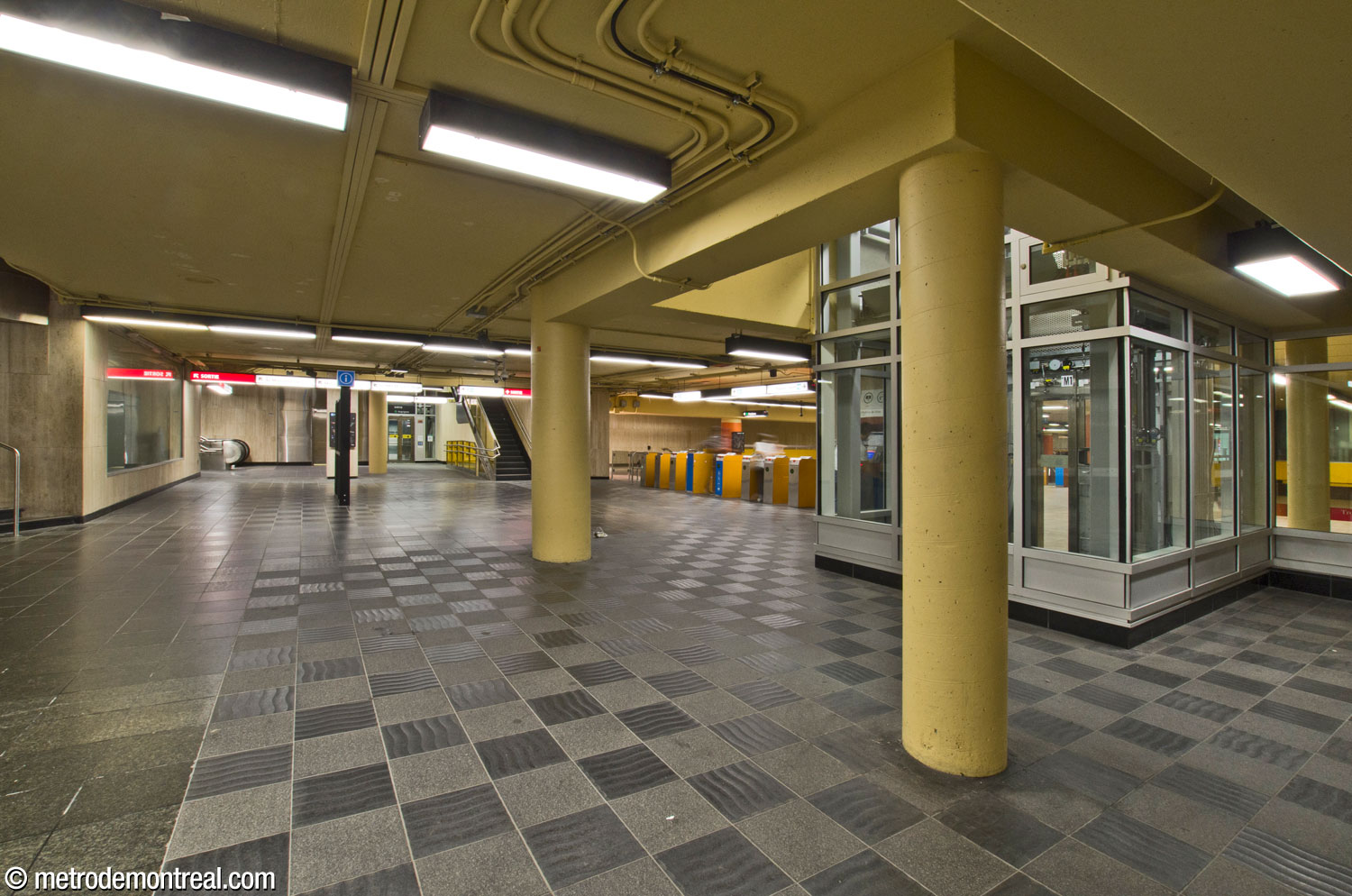 The western concourse. At the far end (left), beside the access to the McGill College exit, is the elevator to the surface and the Angrignon platform, outside the fare-paid zone, with the narrow stairwells that accompany it. For its part, the elevator to the Honoré-Beaugrand platform (left) opens within the western fare-paid zone and is reached via the unstaffed gateline (centre).