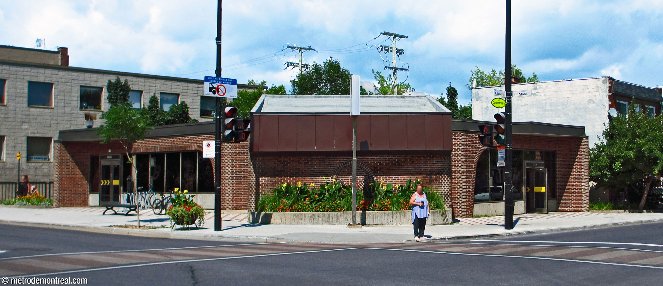 Exterior view of Monk Nord headhouse from across the street, showing its metro-logo decoration and exits on either side.