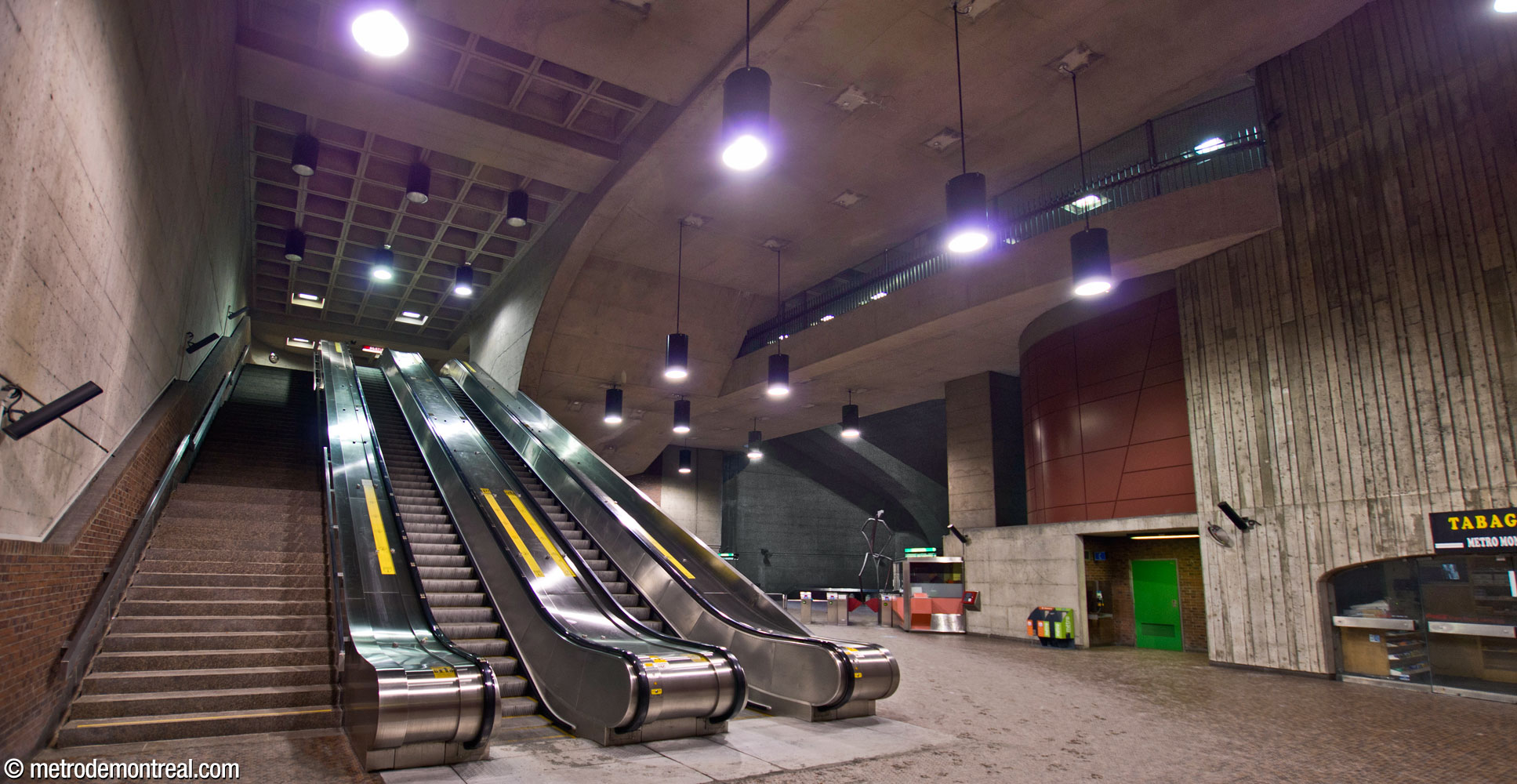 The ticket hall seen from the foot of the escalators. The arrangement of accesses to the headhouses can be seen in the forms of the ceiling: at the centre is the stairwell to the south headhouse, while at right is the bridge leading to the north headhouse, overlooking the volume on either side.