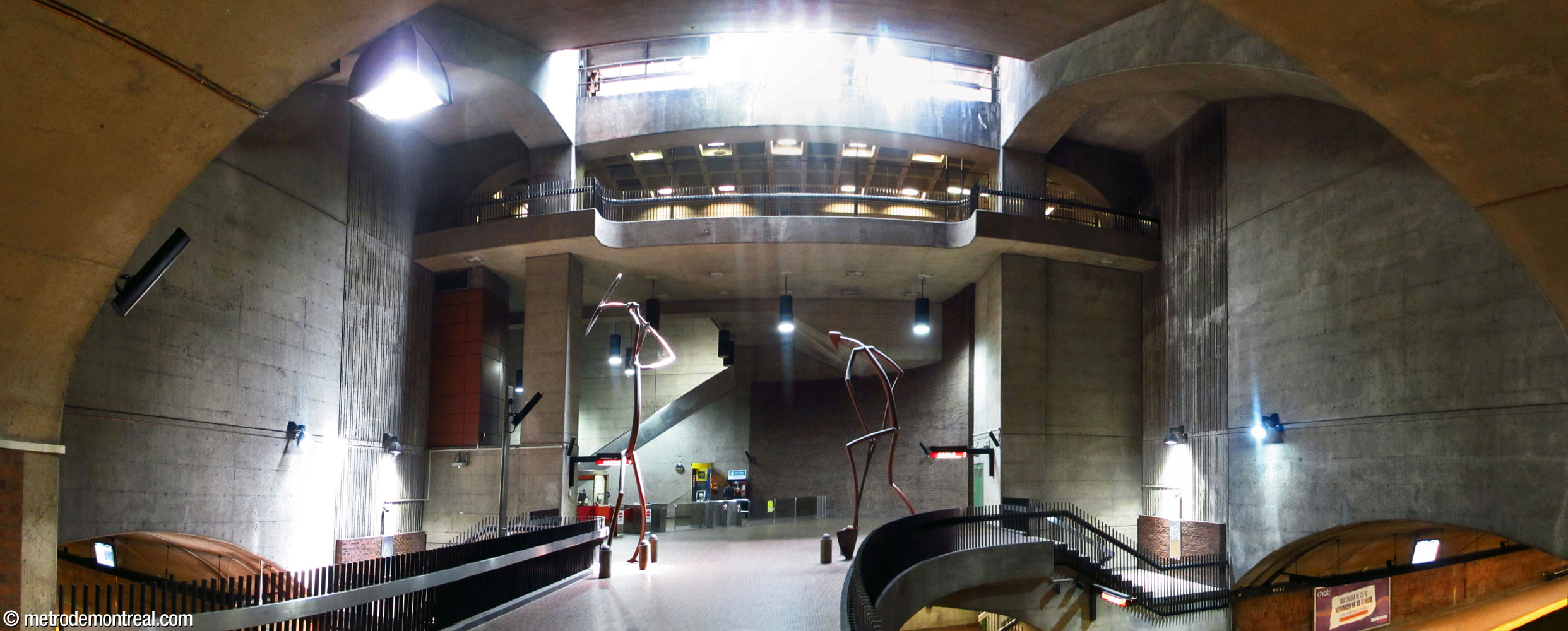 The main volume seen from the head of the stairs to the Angrignon platform. Notice the curve of the crossover, the light shaft illuminating the volume, and the sculptures Pic et Pelle by Germain Bergeron.