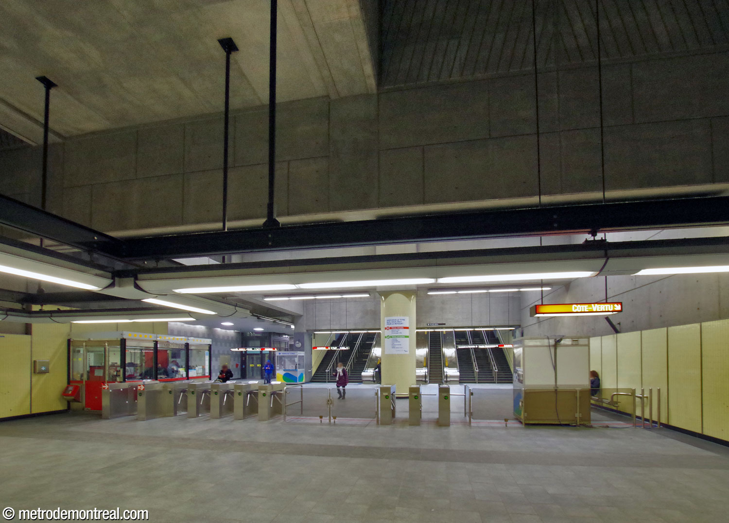 The broad ticket hall and gateline seen from the fare-paid zone.