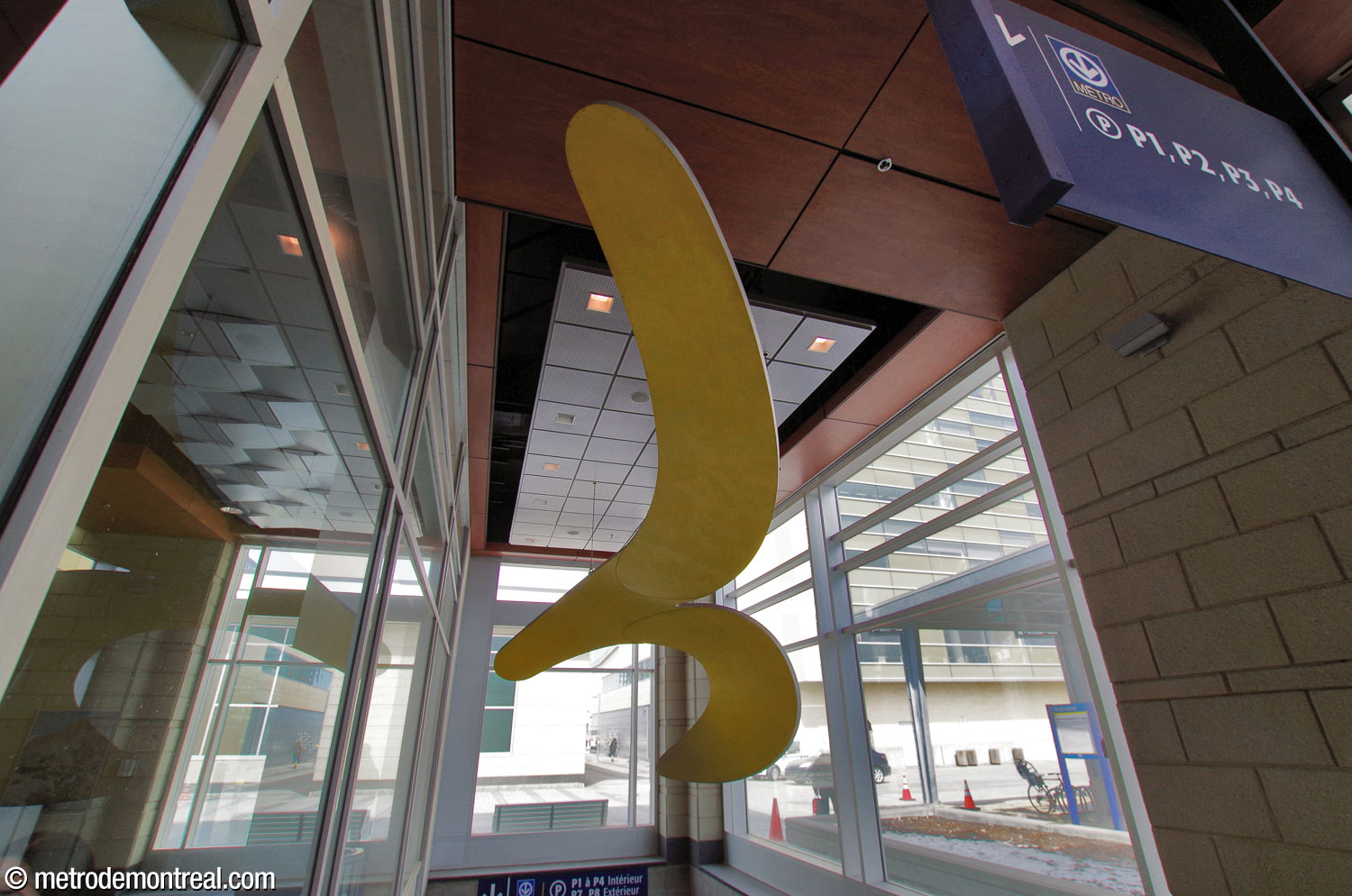 The fourth segment of Hélène Rochette's artwork Les fluides, coloured yellow, is suspended in the stairwell in the bus terminal building leading down to the metro station.