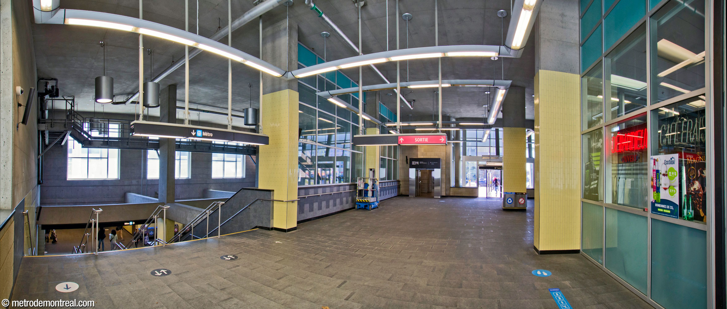 Interior of the metro headhouse. A broad staircase (left) leads down to the concourse and the stairwell down to the ticket hall. At centre, next to the door, is the elevator access to Espace Montmorency; it connects to this level to provide access to the elevator between the street level and the metro ticket hall.