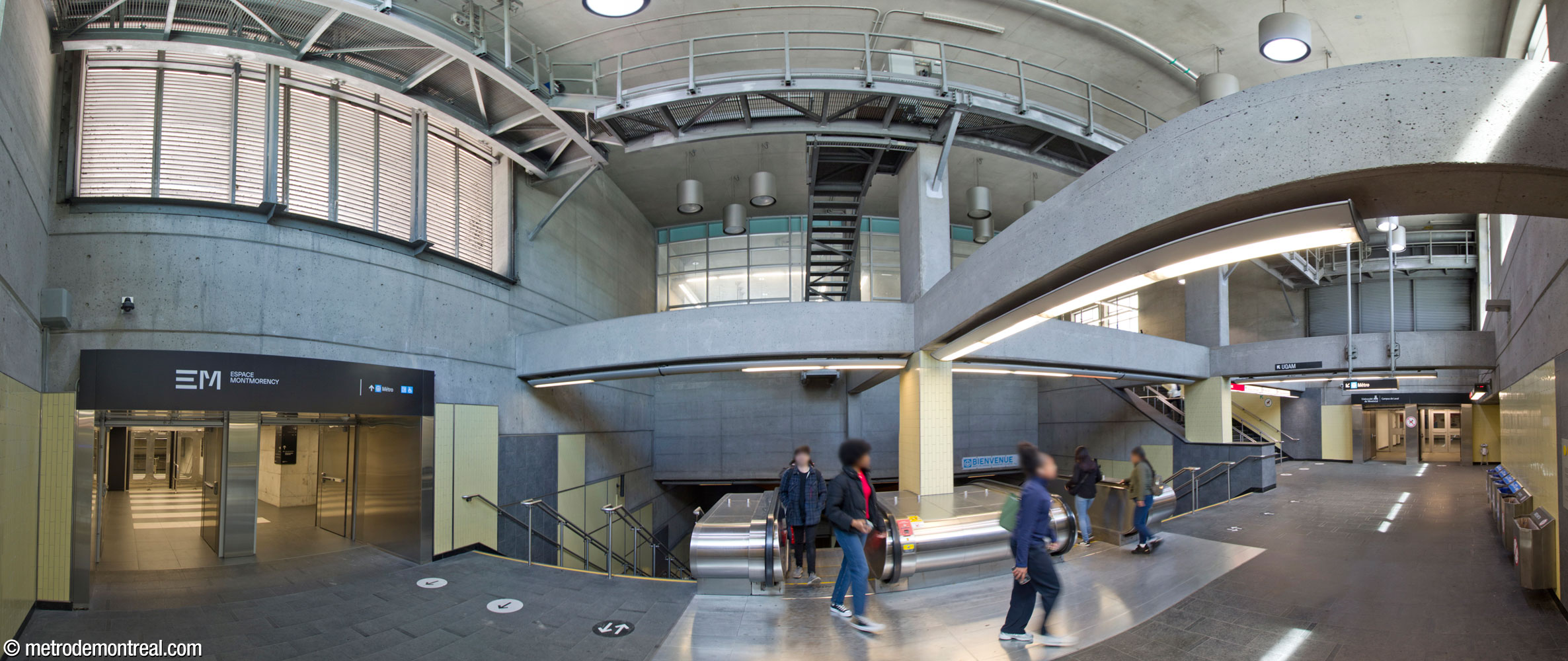 The concourse at the head of the main stairwell (centre) down to the metro station's ticket hall. At right are the stairs to the metro headhouse; facing the feet of this staircase is the access to the bus terminal and parking garage. This concourse also receives the underground city links to Espace Montmorency (left) and the Laval campus of the Université de Montréal (right).
