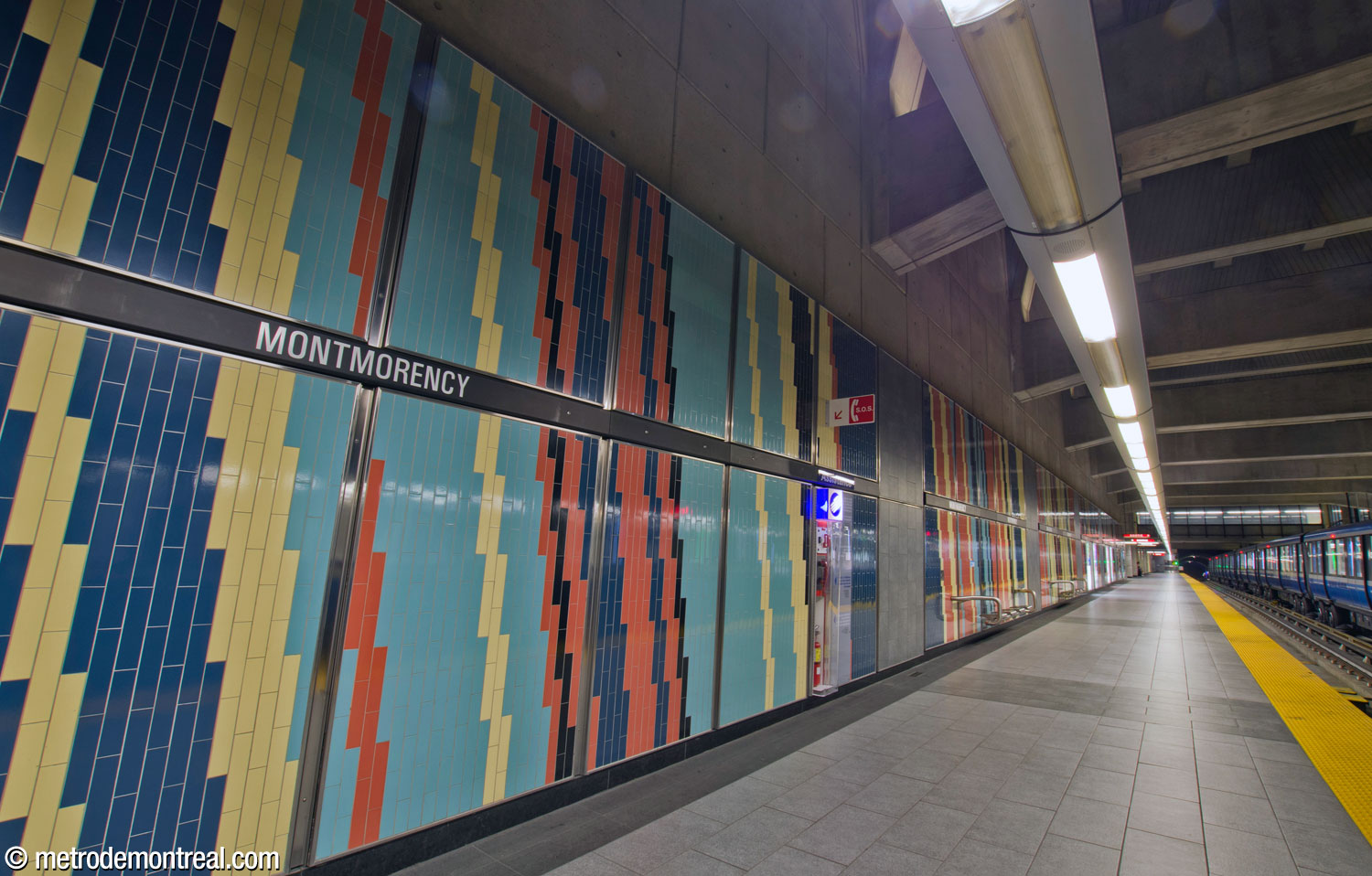Detail of the diagonal stripes in the platform tiling, in yellow, red, aqua, dark blue, and black.