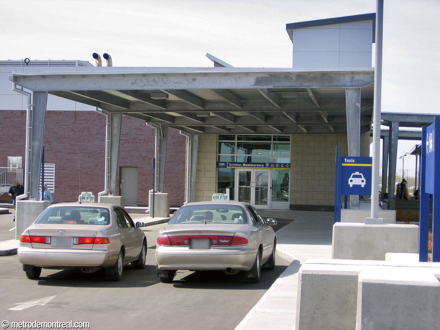 The south entrance to the bus terminal building adjoins the taxi stand and kiss-and-ride area, offering a covered waiting area for these.