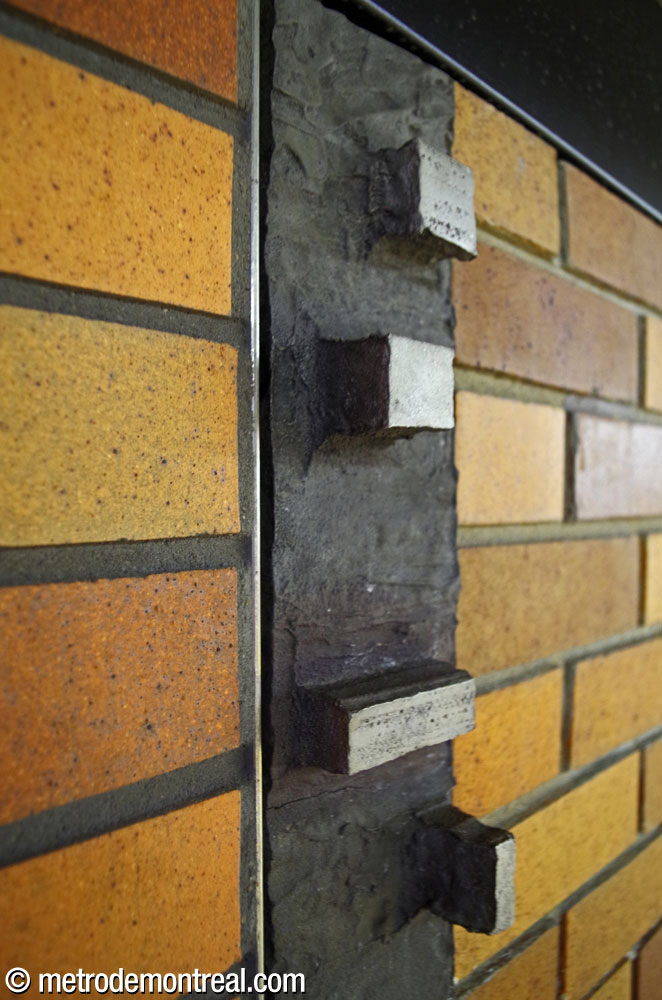 Detail of one of Charles Daudelin's 32 sculptural aluminum wall seams, showing its arrangement of protruding rectangular shapes.