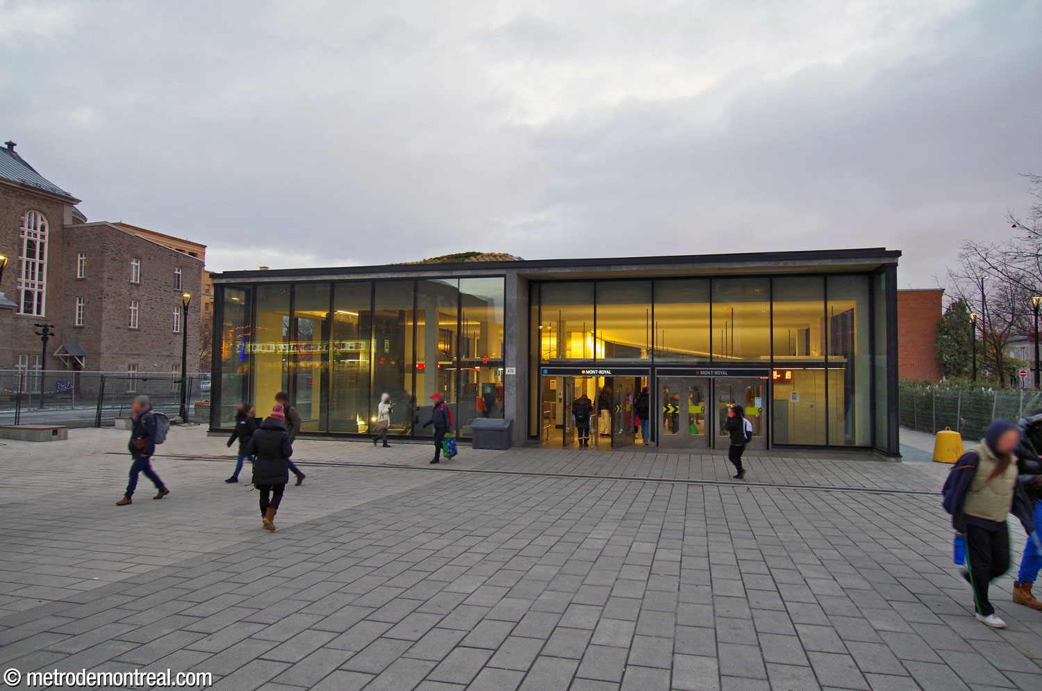 The large new headhouse stands in the centre of Place Gérald-Godin. After dark, light streams from its fully glazed façade.