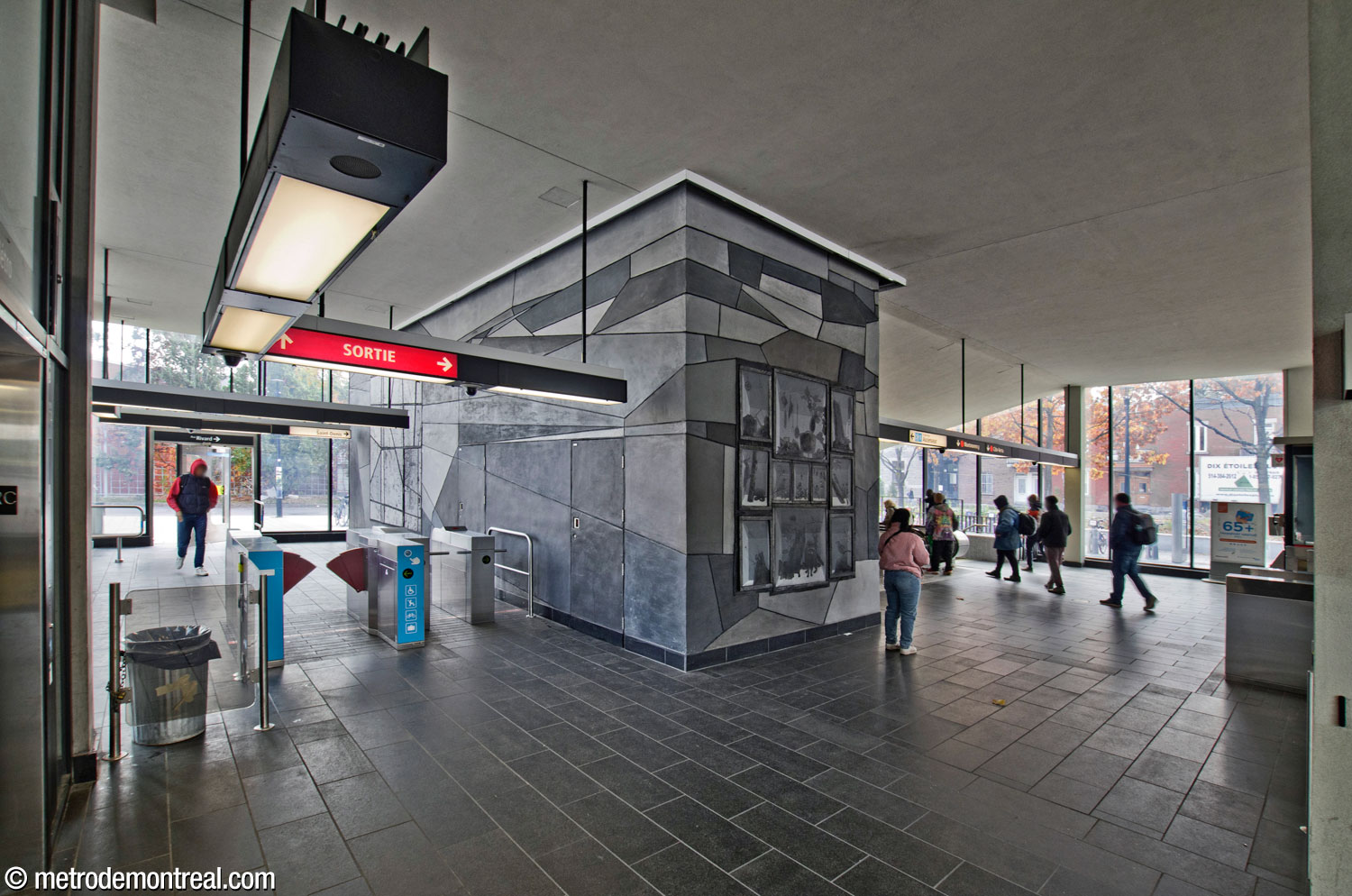 An entrance at the rear of the headhouse (left) is served by a separate gateline. The elevator is at far left. At right, passengers head toward the original stairwell to the platforms. At the centre is Simon Bilodeau's mural Je reviens chez nous.