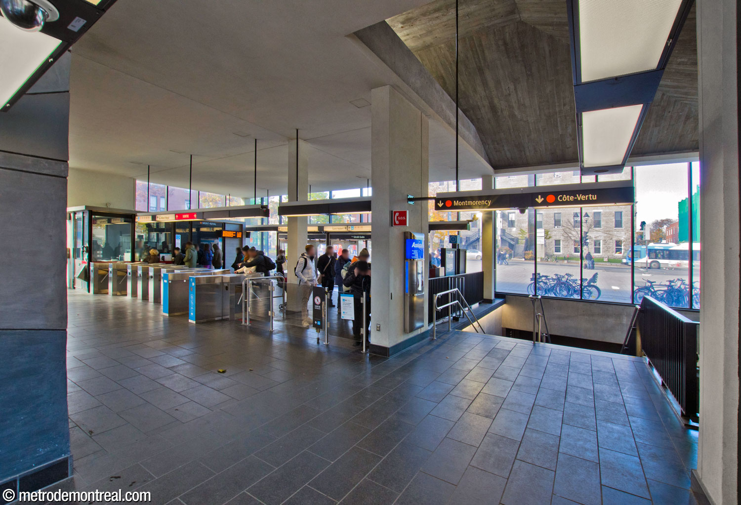 The interior of the headhouse seen from the eastern end of the fare-paid zone, facing back toward the main entrance and main gateline. At right is the new stairwell to the north end of the platforms.