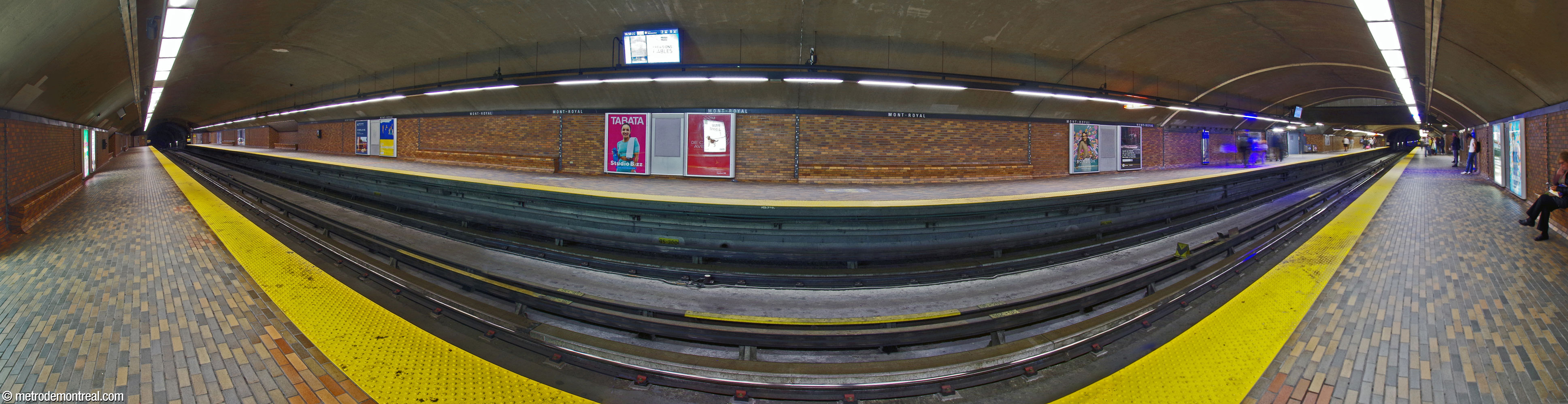 Panorama of the trainroom from the Montmorency platform. Built in tunnel, the platforms are decorated in warm brown terra cotta brick. The benches are built into the walls, which are divided up by Charles Daudelin's 32 metal sculptures. The accesses are at the north end of the station (right).