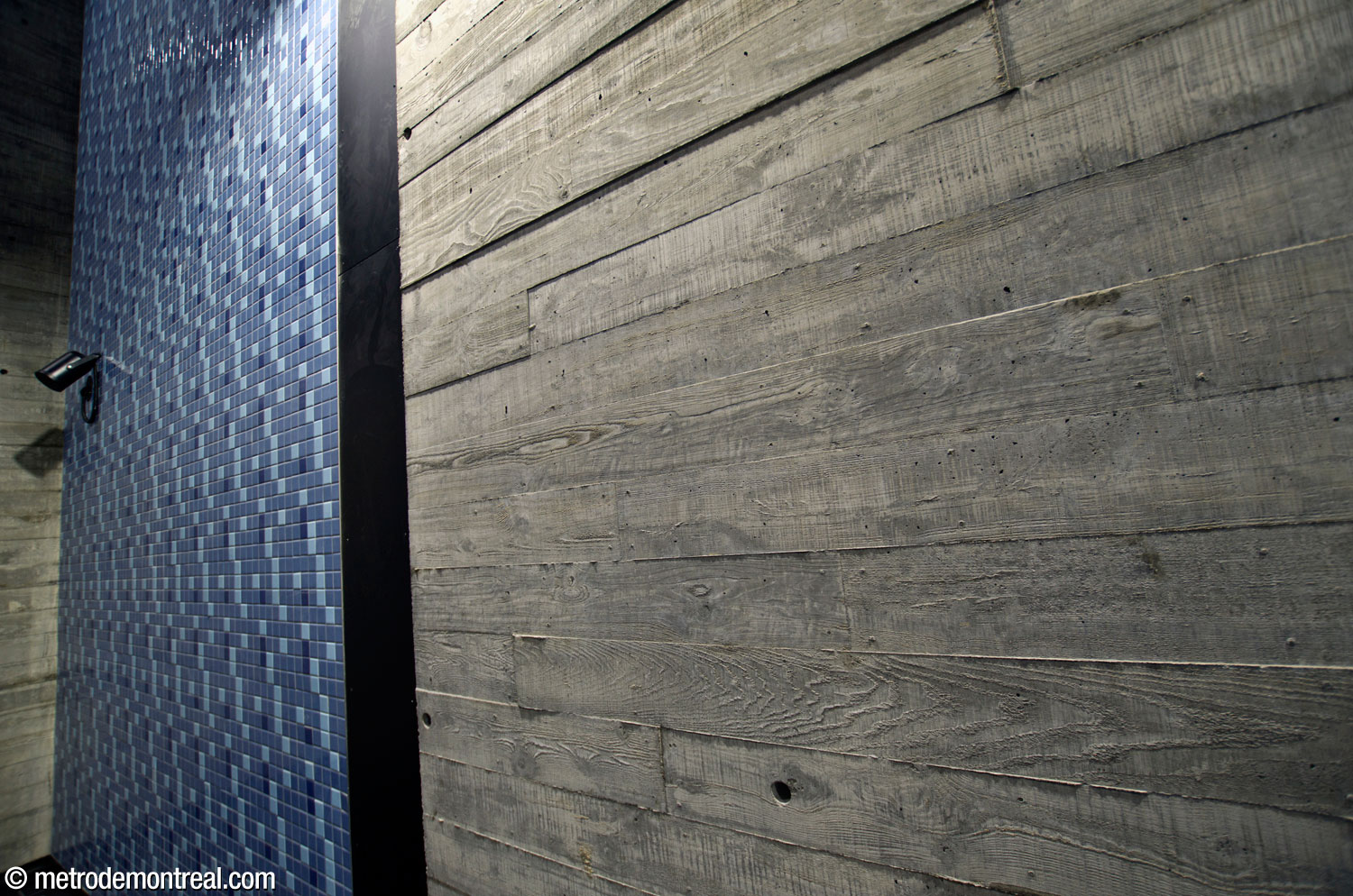 Two unique textures found in the new stairwell to the Montmorency platform pay homage to the station's history. The blue tiled panel suggests the ceramic finishes used elsewhere in the original network, while the wood grain on the concrete (made by moulding actual boards) references the clapboard houses of the historic working-class neighbourhood.