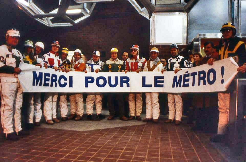 Jockeys from Blue Bonnets Racetrack pose in the ticket hall with a banner during the station's inauguration, January 9, 1984