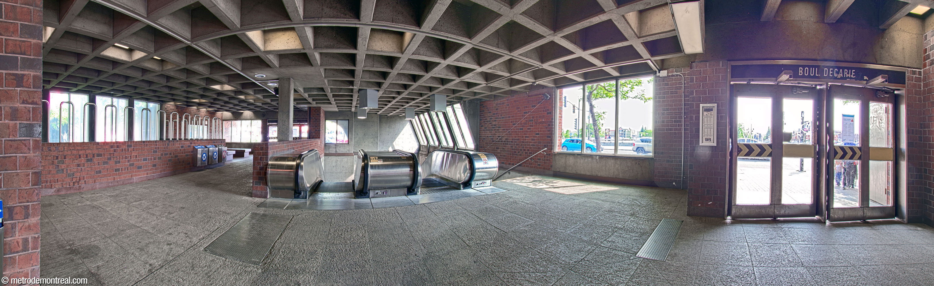 Panorama of the interior of the headhouse, seen from the rear. From left to right, a light shaft, above the foot of the main stairwell in the ticket hall; the Jean-Talon exit; the stairwell down to the station, illuminated by slanted windows; and the he Boulevard Décarie exit. Note the square ceiling coffers and the stepped concrete wall above the stairwell.