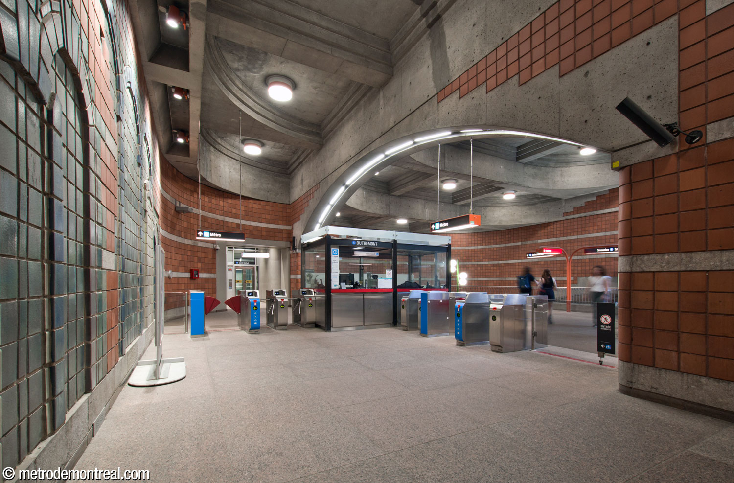 The area at the rear of the ticket hall, divided from the main volume by an archway. The ticket booth stands underneath the archway and the elevator to the Saint-Michel platform is at the far end.