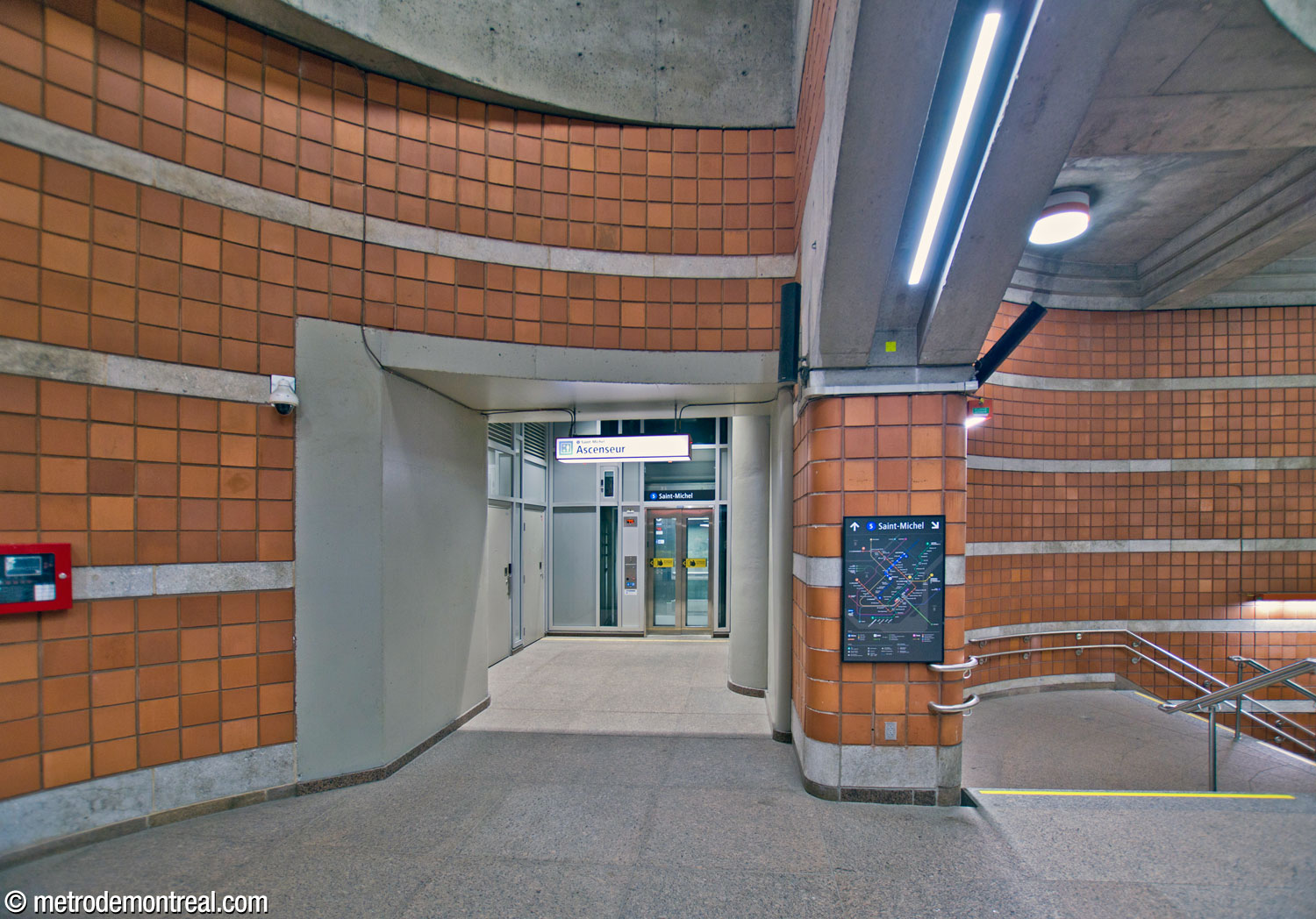 The head of the elevator to the Saint-Michel platform is located at the end of the area outside the large arch, behind the ticket hall mezzanine.